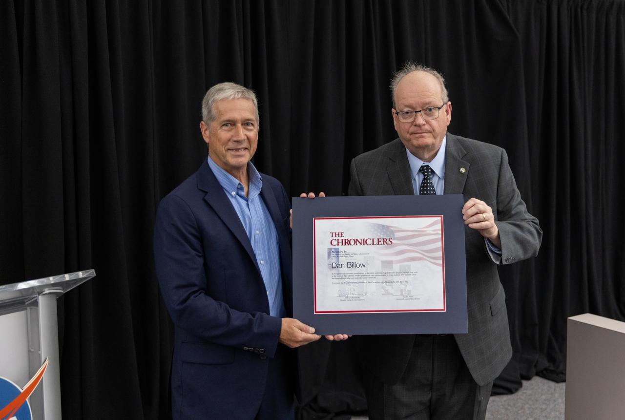Dan Billow accepts a certificate naming him a Kennedy Chronicler during a May 15 ceremony at the Press Site at NASA’s Kennedy Space Center in Florida. Presenting the award is Burt Summerfield, NASA Kennedy Space Center’s associate director, management. Billow, a retired television broadcaster, was among three reporters and industry professionals who were nominated by their peers and selected by a panel of NASA officials and current space reporters. Brass plates bearing their names were added to the wall of the “bull pen,” where reporters traditionally gather to cover launches and events at NASA Kennedy.