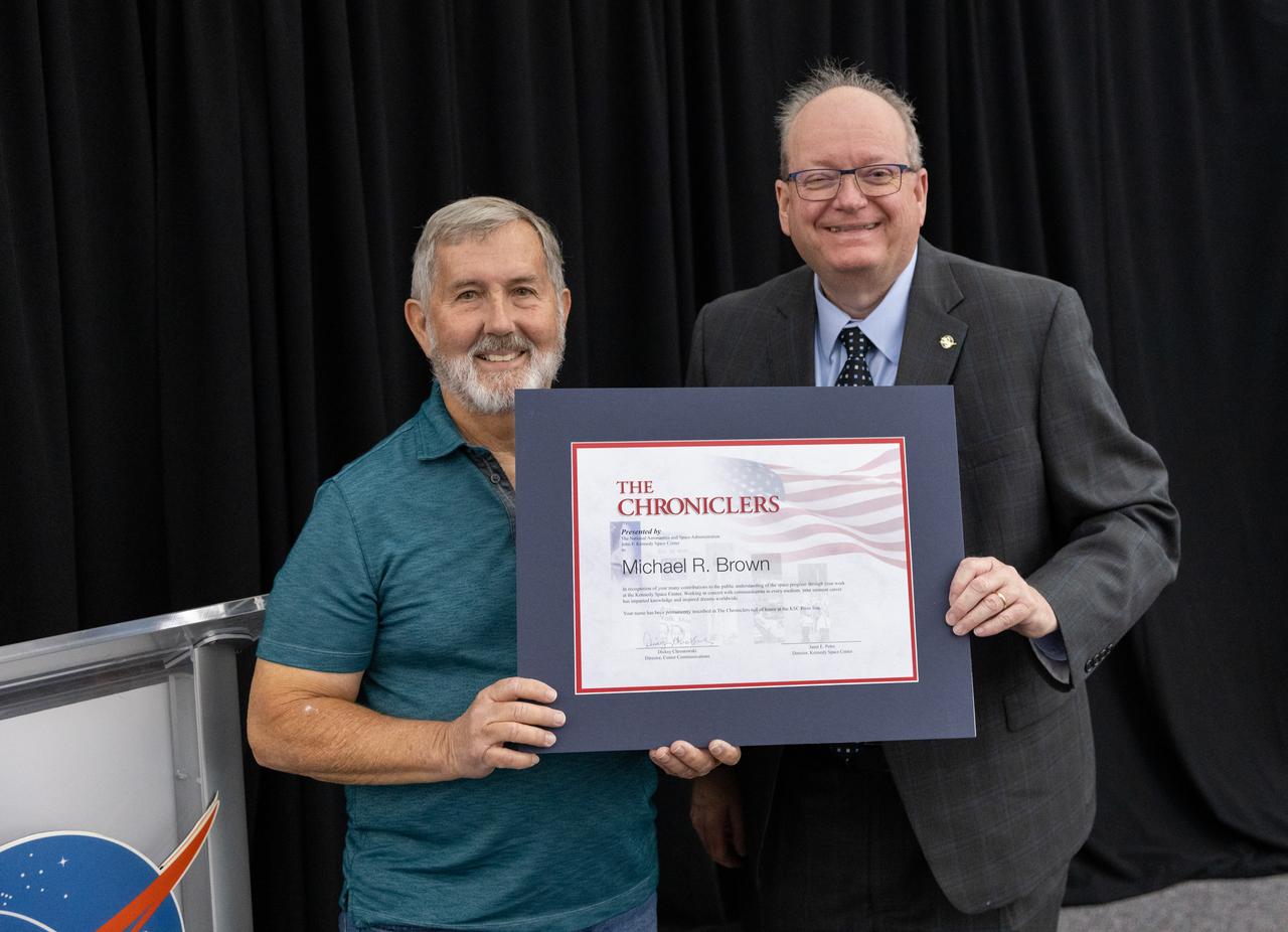 Mike Brown accepts a certificate naming him a Kennedy Chronicler during a May 15 ceremony at the Press Site at NASA’s Kennedy Space Center in Florida. Presenting the award is Burt Summerfield, NASA Kennedy Space Center’s associate director, management. Brown, a long-time space photographer, was among three reporters and industry professionals who were nominated by their peers and selected by a panel of NASA officials and current space reporters for their efforts in helping tell the story of America’s space program. Brass plates bearing their names were added to the wall of the “bull pen,” where reporters traditionally gather to cover launches and events at NASA Kennedy.