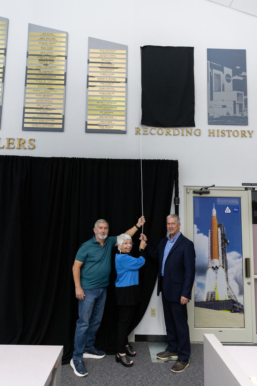 Mike Brown, Maggie Persinger, and Dan Billow were honored May 15, 2024, during the 2024 Kennedy Chroniclers ceremony at the Press Site at NASA’s Kennedy Space Center in Florida. Three brass plates bearing their names were added to the wall of the “bull pen,” where reporters traditionally gather to cover launches and events at NASA Kennedy. The three were honored for their efforts in helping tell the story of America’s space program, primarily from the Florida spaceport. They were nominated by their peers and selected by a panel of NASA officials and current space reporters.