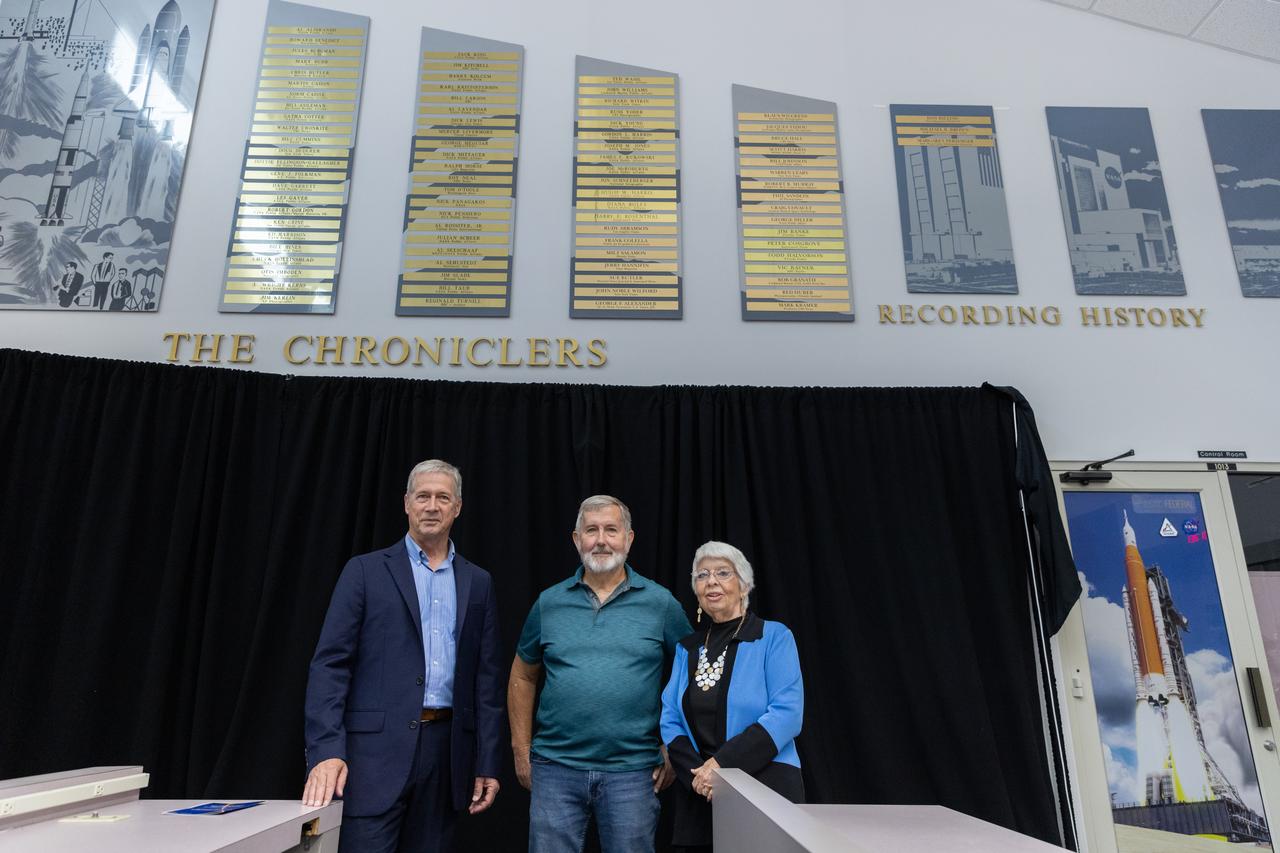 Dan Billow, Mike Brown, and Maggie Persinger were honored May 15, 2024, during the 2024 Kennedy Chroniclers ceremony at the Press Site at NASA’s Kennedy Space Center in Florida. Three brass plates bearing their names were added to the wall of the “bull pen,” where reporters traditionally gather to cover launches and events at NASA Kennedy. The three were honored for their efforts in helping tell the story of America’s space program, primarily from the Florida spaceport. They were nominated by their peers and selected by a panel of NASA officials and current space reporters.