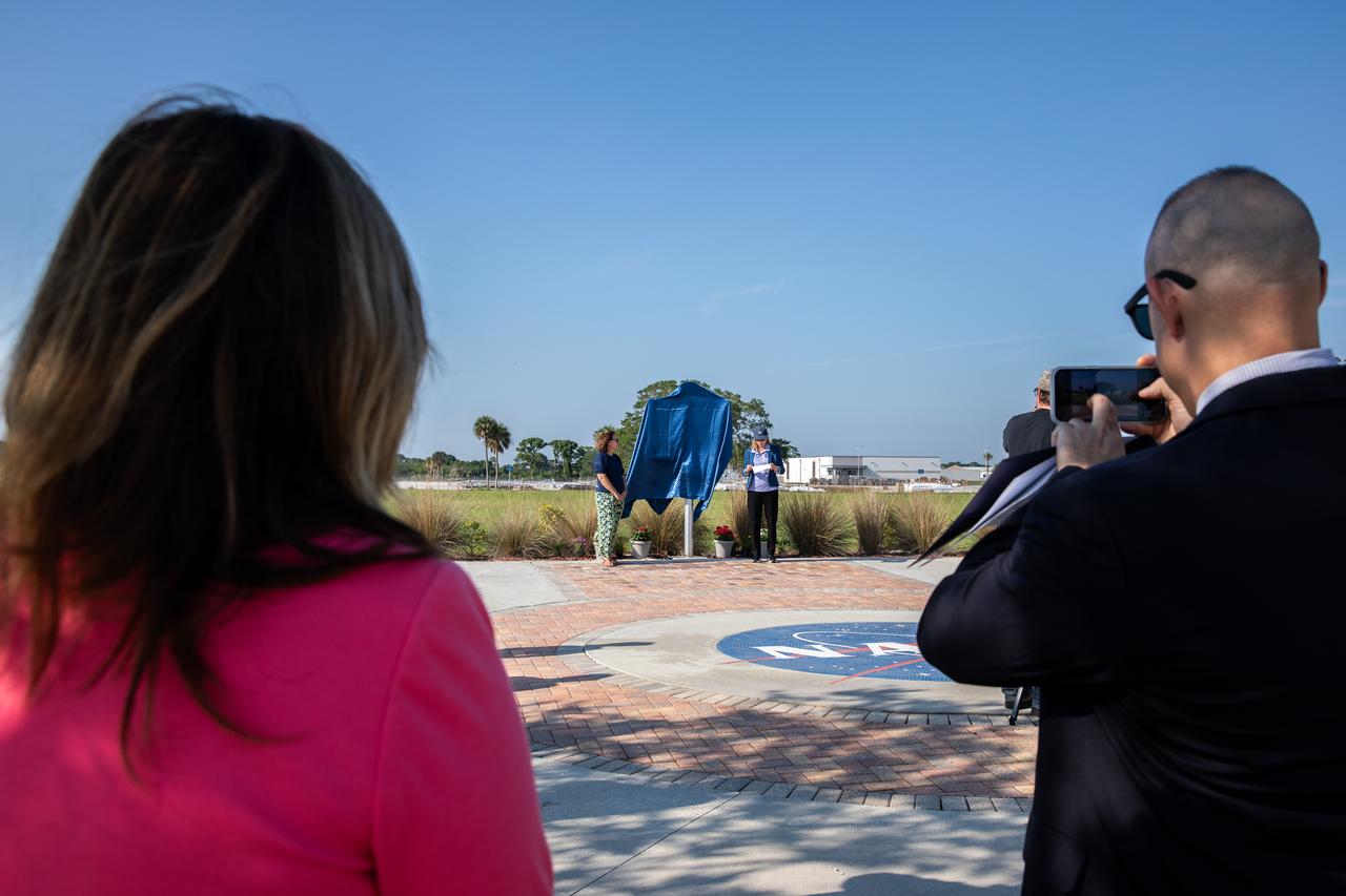 From the left, Katherine Zeringue, cultural resources manager, NASA’s Kennedy Space Center, is joined by Janet Petro, NASA Kennedy Space Center director, at a ceremony attended by NASA employees held Tuesday, May 28, 2024, to unveil a large bronze historical marker plaque at the location of NASA Kennedy’s original headquarters building. Approved in April 2023 as part of the State of Florida’s Historical Markers program in celebration of National Historic Preservation Month, the marker commemorates the early days of space exploration and is displayed permanently just west of the seven-story, 200,000 square foot Central Campus Headquarters Building, which replaced the old building in 2019. 