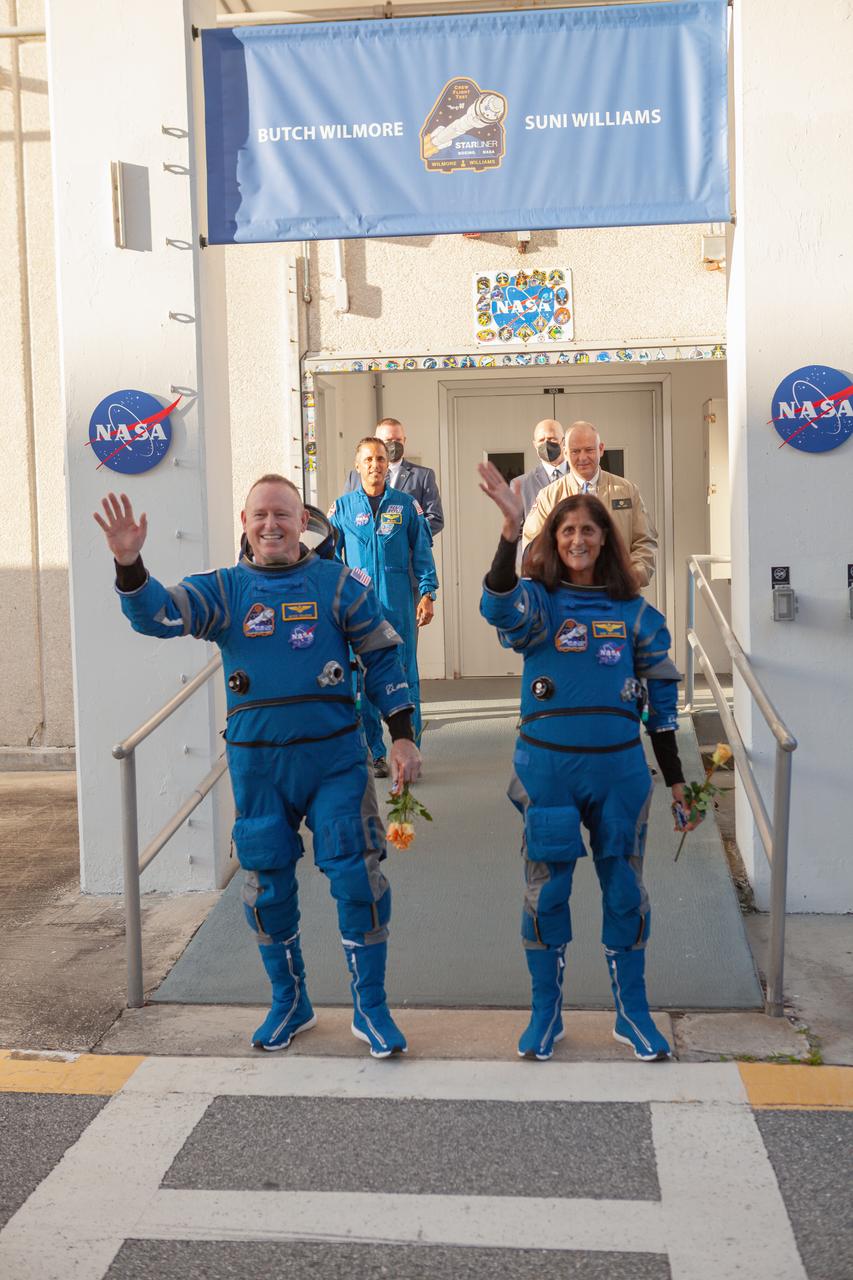 NASA’s Boeing Crew Flight Test astronauts Butch Wilmore and Suni Williams wave goodbye to friends and family upon exiting the Neil A. Armstrong Operations and Checkout Building at NASA’s Kennedy Space Center in Florida on Wednesday, June 5, 2024. The crew members are on their way to load up into Boeing’s Astrovan for the trip to the launch pad of Space Launch Complex-41 at nearby Cape Canaveral Space Force Station, where they will launch to the International Space Station aboard Boeing’s Starliner spacecraft atop a United Launch Alliance Atlas V rocket at 10:52 a.m. EDT.
