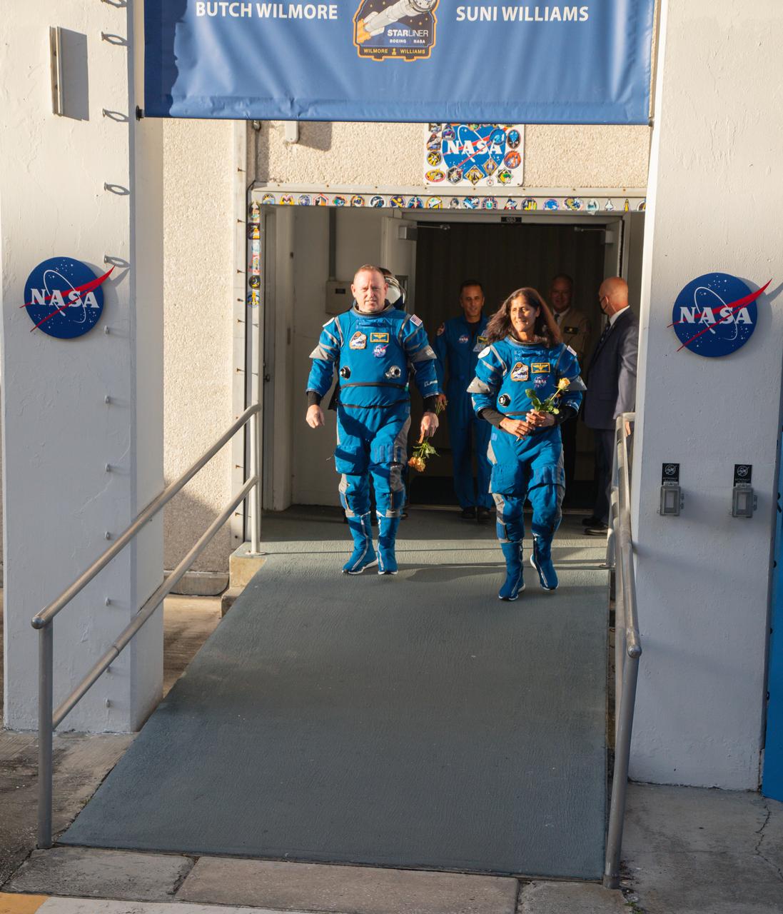NASA’s Boeing Crew Flight Test astronauts Butch Wilmore and Suni Williams walk out of the Neil A. Armstrong Operations and Checkout Building on Wednesday, June 5, 2024, at the agency’s Kennedy Space Center in Florida. The crew members are on their way to load up into Boeing’s Astrovan for the trip to the launch pad of Space Launch Complex-41 at nearby Cape Canaveral Space Force Station, where they will launch to the International Space Station aboard Boeing’s Starliner spacecraft atop a United Launch Alliance Atlas V rocket at 10:52 a.m. EDT.