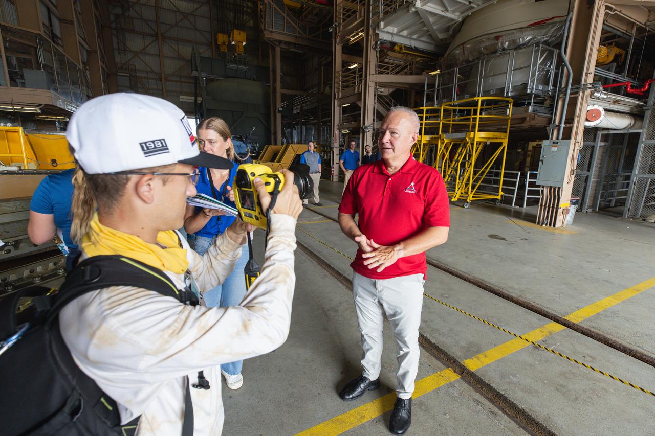 Doug Hurley, senior director at Northrop Grumman and former NASA astronaut, speaks to the media near one of the aft skirts of the solid rocket booster segments inside the Rotation, Processing and Surge Facility (RPSF) at Kennedy Space Center in Florida on Tuesday, July 23, 2024. The booster segments will help propel the SLS (Space Launch System) rocket on the Artemis II mission to send four astronauts around the Moon as part of the agency’s effort to establish a long-term science and exploration presence at the Moon, and eventually Mars.