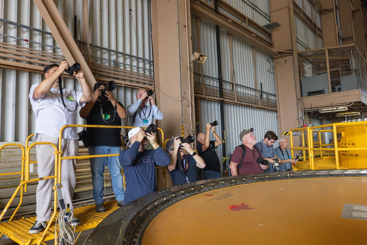 Members of the media take photos of the aft skirts of the solid rocket booster segments inside the Rotation, Processing and Surge Facility (RPSF) at Kennedy Space Center in Florida on Tuesday, July 23, 2024. The booster segments will help propel the SLS (Space Launch System) rocket on the Artemis II mission to send four astronauts around the Moon as part of the agency’s effort to establish a long-term science and exploration presence at the Moon, and eventually Mars.