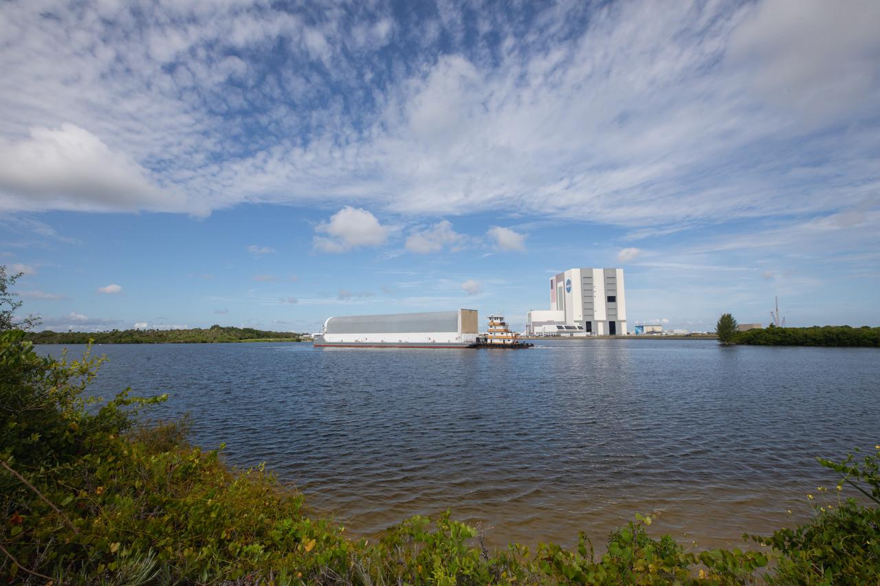 NASA’s Pegasus barge, carrying the agency’s massive SLS (Space Launch System) core stage, arrives at NASA’s Kennedy Space Center Complex 39 turn basin wharf in Florida on Tuesday, July 23, 2024, after journeying from the agency’s Michoud Assembly Facility in New Orleans. The core stage is the next piece of Artemis hardware to arrive at the spaceport and will be offloaded and moved to NASA Kennedy’s Vehicle Assembly Building, where it will be prepared for integration ahead of the Artemis II launch.