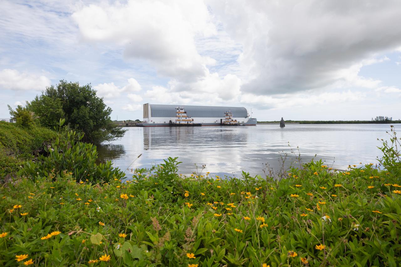 NASA’s Pegasus barge, carrying the agency’s massive SLS (Space Launch System) core stage, arrives at NASA’s Kennedy Space Center Complex 39 turn basin wharf in Florida on Tuesday, July 23, 2024, after journeying from the agency’s Michoud Assembly Facility in New Orleans. The core stage is the next piece of Artemis hardware to arrive at the spaceport and will be offloaded and moved to NASA Kennedy’s Vehicle Assembly Building, where it will be prepared for integration ahead of the Artemis II launch.