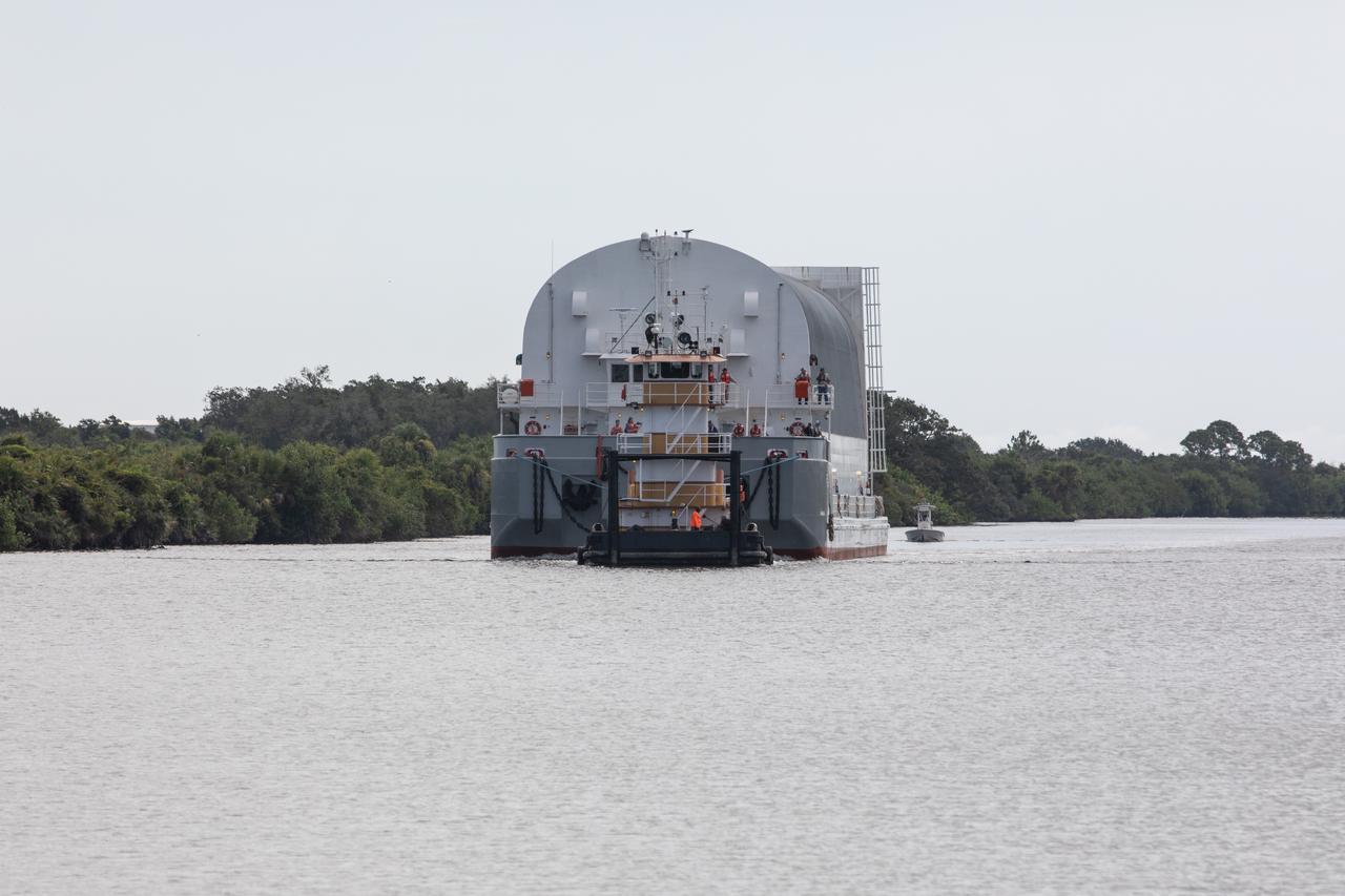 Behind the iconic countdown clock at NASA’s Kennedy Space Center in Florida, the agency’s Pegasus barge completes its 900-mile journey from NASA’s Michoud Assembly Facility in New Orleans carrying the powerful SLS (Space Launch System) core stage on Tuesday, July 23, 2024. Teams with NASA's Exploration Ground Systems (EGS) will offload the rocket stage and transfer it to the spaceport’s Vehicle Assembly Building to prepare it for integration atop the mobile launcher ahead of the Artemis II launch.