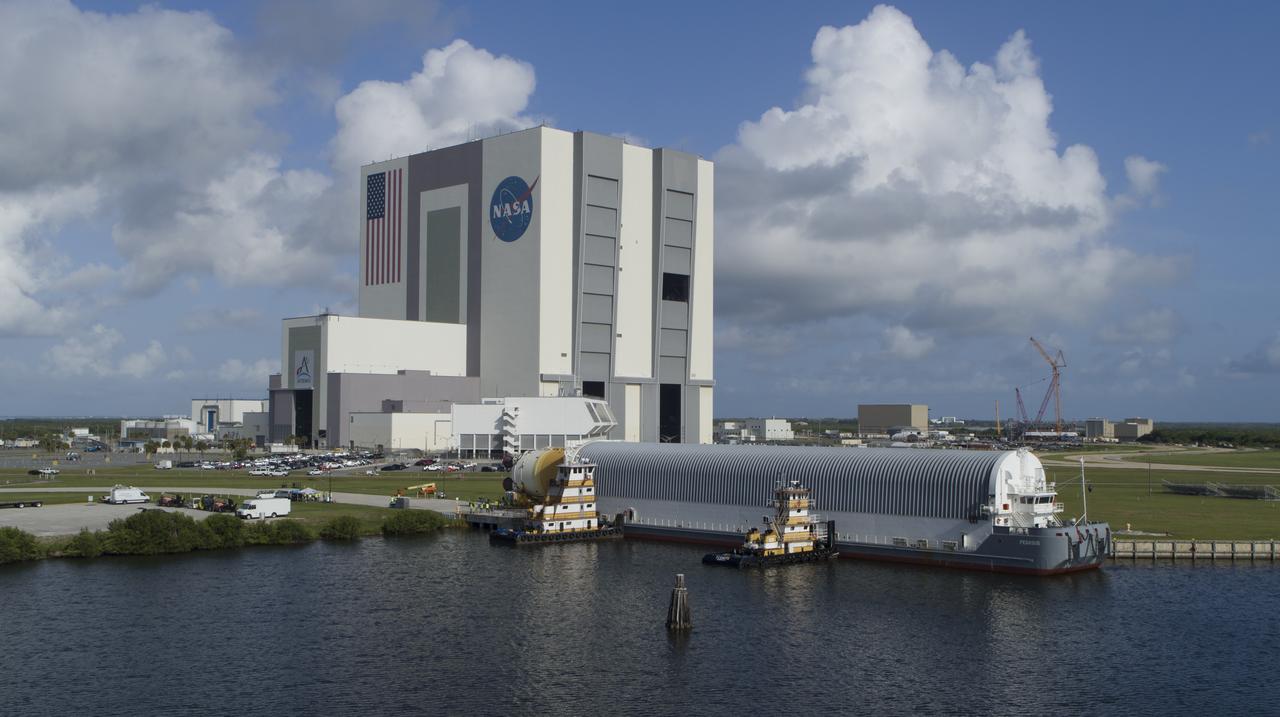 In this aerial view, NASA’s powerful 212-foot long SLS (Space Launch System) core stage is shown being offloaded from the agency’s Pegasus Barge on Wednesday, July 24, 2024, after arriving at NASA’s Kennedy Space Center in Florida. Teams with Exploration Ground Systems (EGS) will transfer the rocket stage to the spaceport’s Vehicle Assembly Building to prepare it for integration atop the mobile launcher ahead of the Artemis II launch.