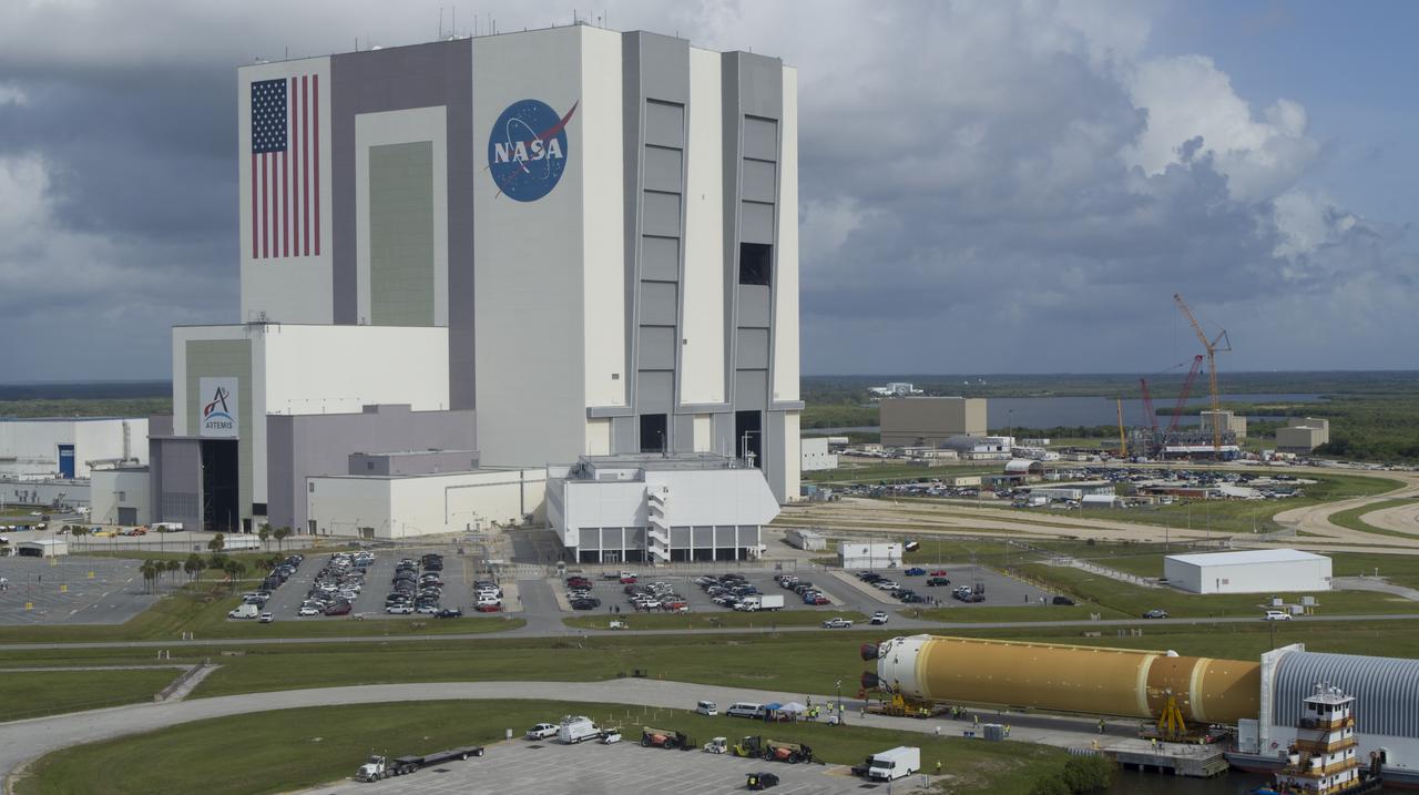 In this aerial view, NASA’s powerful 212-foot long SLS (Space Launch System) core stage is shown being offloaded from the agency’s Pegasus Barge on Wednesday, July 24, 2024, after arriving at NASA’s Kennedy Space Center in Florida. Teams with Exploration Ground Systems (EGS) will transfer the rocket stage to the spaceport’s Vehicle Assembly Building to prepare it for integration atop the mobile launcher ahead of the Artemis II launch.