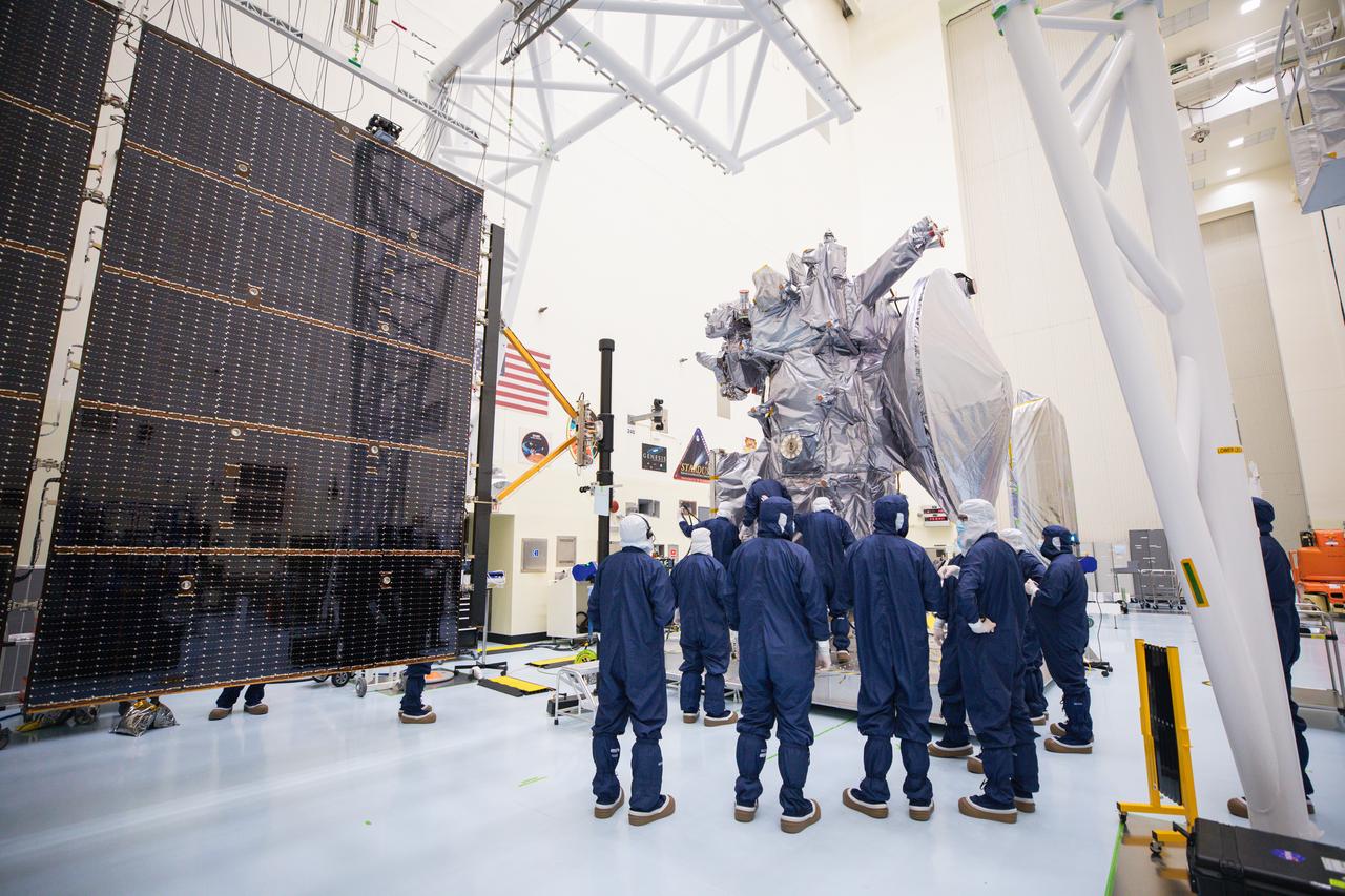 Technicians attach the five-panel solar arrays to NASA’s Europa Clipper spacecraft inside the Payload Hazardous Servicing Facility at the agency’s Kennedy Space Center in Florida on Friday, Aug. 2, 2024. The huge arrays – spanning more than 100 feet when fully deployed, or about the length of a basketball court – will collect sunlight to power the spacecraft as it explores Jupiter’s icy moon, Europa, conducting science investigations to determine its potential to support life.