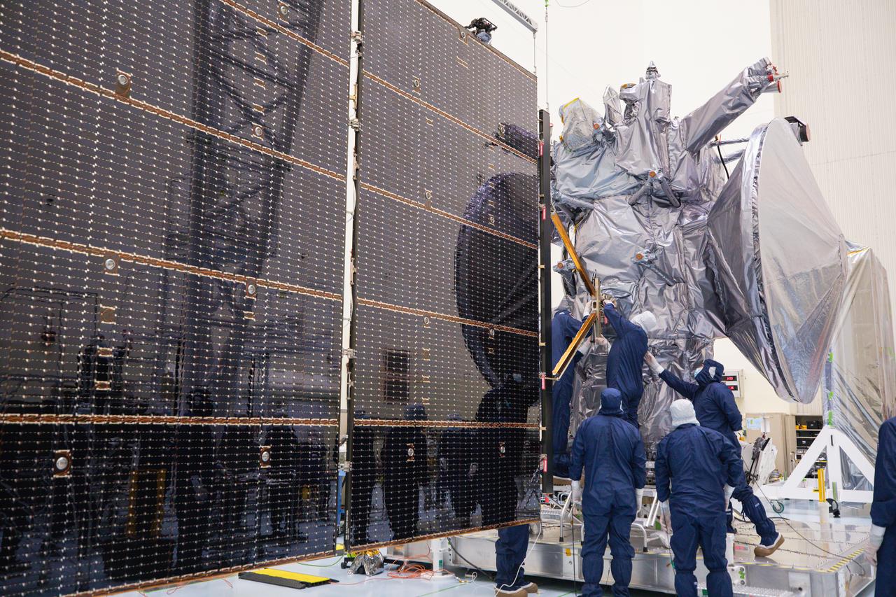 Technicians attach the five-panel solar arrays to NASA’s Europa Clipper spacecraft inside the Payload Hazardous Servicing Facility at the agency’s Kennedy Space Center in Florida on Friday, Aug. 2, 2024. The huge arrays – spanning more than 100 feet when fully deployed, or about the length of a basketball court – will collect sunlight to power the spacecraft as it explores Jupiter’s icy moon, Europa, conducting science investigations to determine its potential to support life.