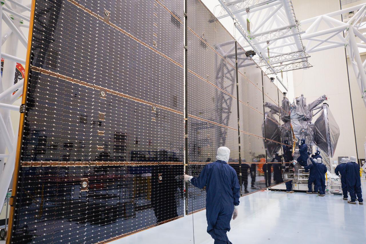 Technicians attach the five-panel solar arrays to NASA’s Europa Clipper spacecraft inside the Payload Hazardous Servicing Facility at the agency’s Kennedy Space Center in Florida on Friday, Aug. 2, 2024. The huge arrays – spanning more than 100 feet when fully deployed, or about the length of a basketball court – will collect sunlight to power the spacecraft as it explores Jupiter’s icy moon, Europa, conducting science investigations to determine its potential to support life.
