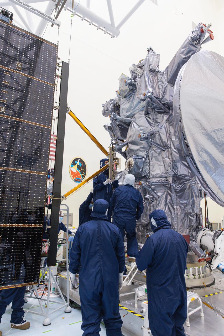 Technicians attach the five-panel solar arrays to NASA’s Europa Clipper spacecraft inside the Payload Hazardous Servicing Facility at the agency’s Kennedy Space Center in Florida on Friday, Aug. 2, 2024. The huge arrays – spanning more than 100 feet when fully deployed, or about the length of a basketball court – will collect sunlight to power the spacecraft as it explores Jupiter’s icy moon, Europa, conducting science investigations to determine its potential to support life.