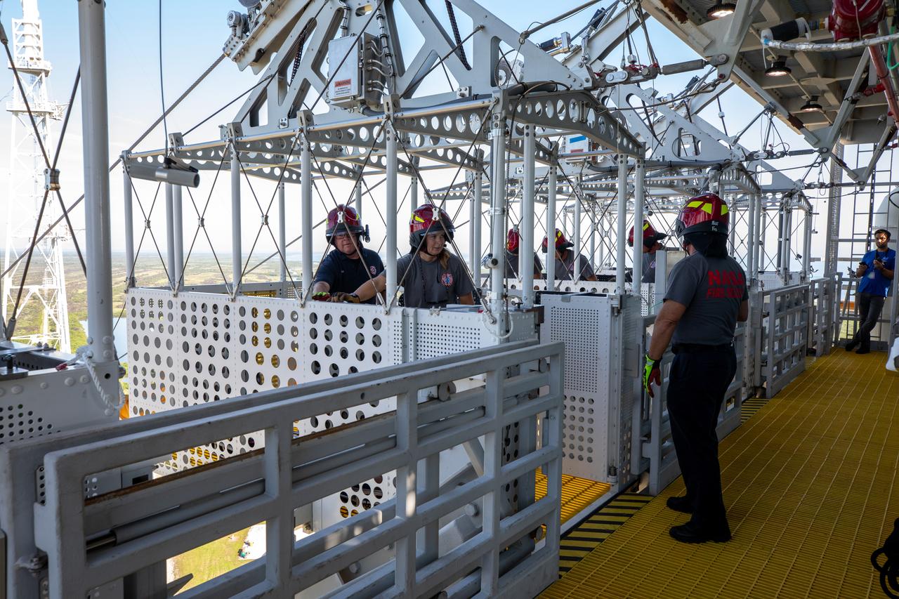 Teams at NASA’s Kennedy Space Center in Florida practice the Artemis mission emergency escape or egress procedures during a series of integrated system verification and validation tests at Launch Pad 39B on Sunday, Aug. 11, 2024. Members of the closeout crew, pad rescue team and the Exploration Ground Systems Program practiced the process of getting inside and out of the emergency egress baskets. While the crew and other personnel will ride the emergency egress baskets to the terminus area in a real emergency, no one rode the baskets for this test. Instead, teams tested the baskets during separate occasions by using water tanks filled to different levels to replicate simulate the weight of passengers. 