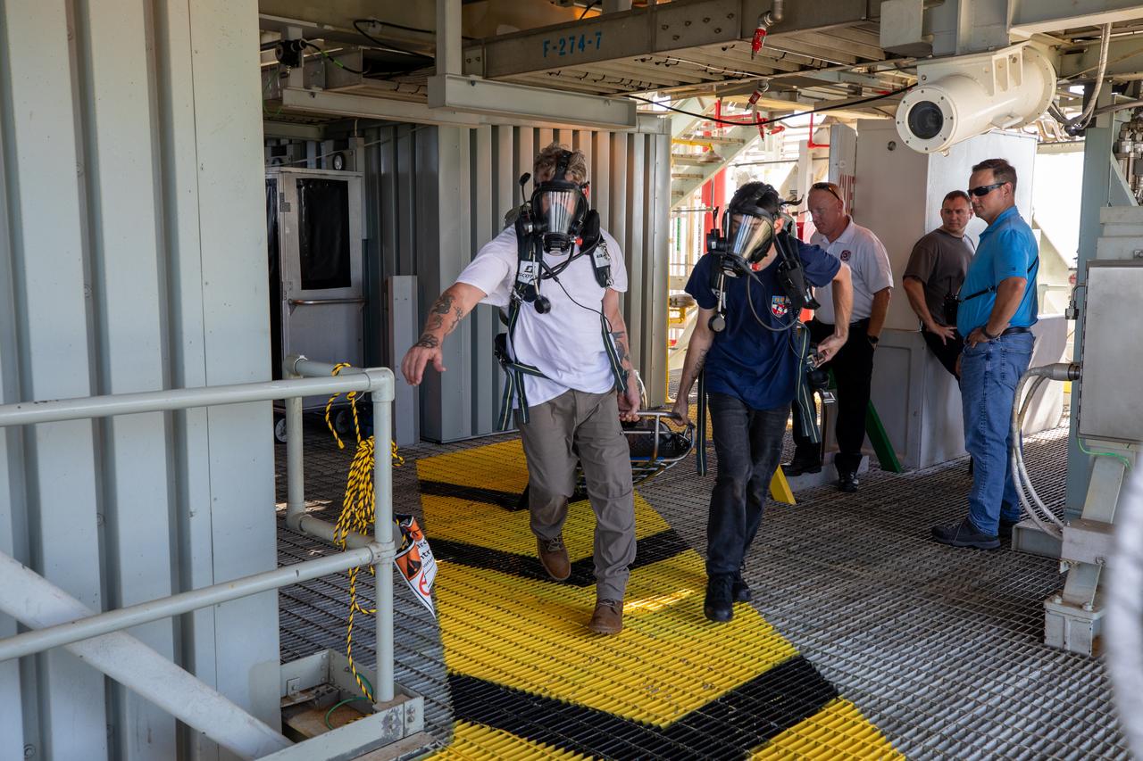 Teams at NASA’s Kennedy Space Center in Florida practice the Artemis mission emergency escape or egress procedures during a series of integrated system verification and validation tests at Launch Pad 39B on Sunday, Aug. 11, 2024. Members of the closeout crew, pad rescue team and the Exploration Ground Systems Program practiced the process of getting inside and out of the emergency egress baskets. While the crew and other personnel will ride the emergency egress baskets to the terminus area in a real emergency, no one rode the baskets for this test. Instead, teams tested the baskets during separate occasions by using water tanks filled to different levels to replicate simulate the weight of passengers. 