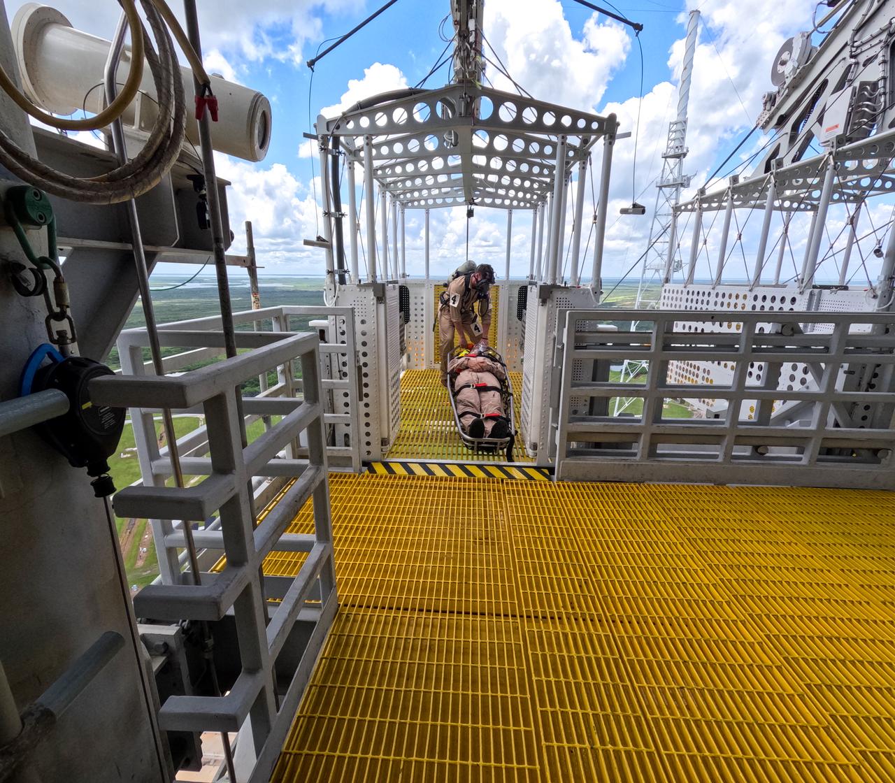Teams at NASA’s Kennedy Space Center in Florida practice the Artemis mission emergency escape or egress procedures during a series of integrated system verification and validation tests at Launch Pad 39B on Sunday, Aug. 11, 2024. Members of the closeout crew, pad rescue team and the Exploration Ground Systems Program practiced the process of getting inside and out of the emergency egress baskets. While the crew and other personnel will ride the emergency egress baskets to the terminus area in a real emergency, no one rode the baskets for this test. Instead, teams tested the baskets during separate occasions by using water tanks filled to different levels to replicate simulate the weight of passengers. 