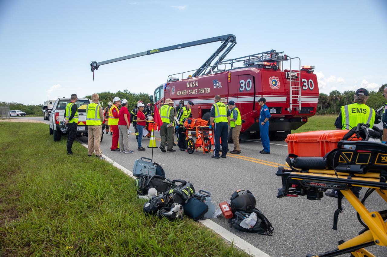Medical, fire-rescue personnel, and simulated flight crew members participate in the Artemis II mission emergency escape or egress verification and validation tests near Launch Complex 39 at NASA's Kennedy Space Center in Florida on Monday, Aug. 12, 2024. During the multi-day tests, members of the closeout crew, pad rescue team, and the Exploration Ground Systems Program practiced the process of getting in and out of the emergency egress baskets then down to the launch pad where they would be transported to emergency transport vehicles and driven to safety. Prior to this test and throughout the course of several months, teams conducted basket release demonstrations to validate the system.