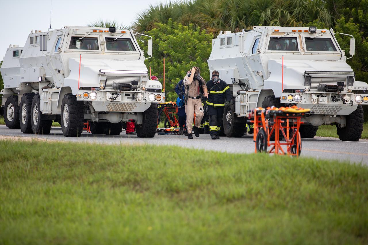 Medical and fire-rescue personnel participate in the Artemis II mission emergency escape or egress verification and validation tests near Launch Complex 39 at NASA's Kennedy Space Center in Florida on Monday, Aug. 12, 2024. During the multi-day tests, members of the closeout crew, pad rescue team, and the Exploration Ground Systems Program practiced the process of getting in and out of the emergency egress baskets then down to the launch pad where they would be transported to emergency transport vehicles and driven to safety. Prior to this test and throughout the course of several months, teams conducted basket release demonstrations to validate the system.