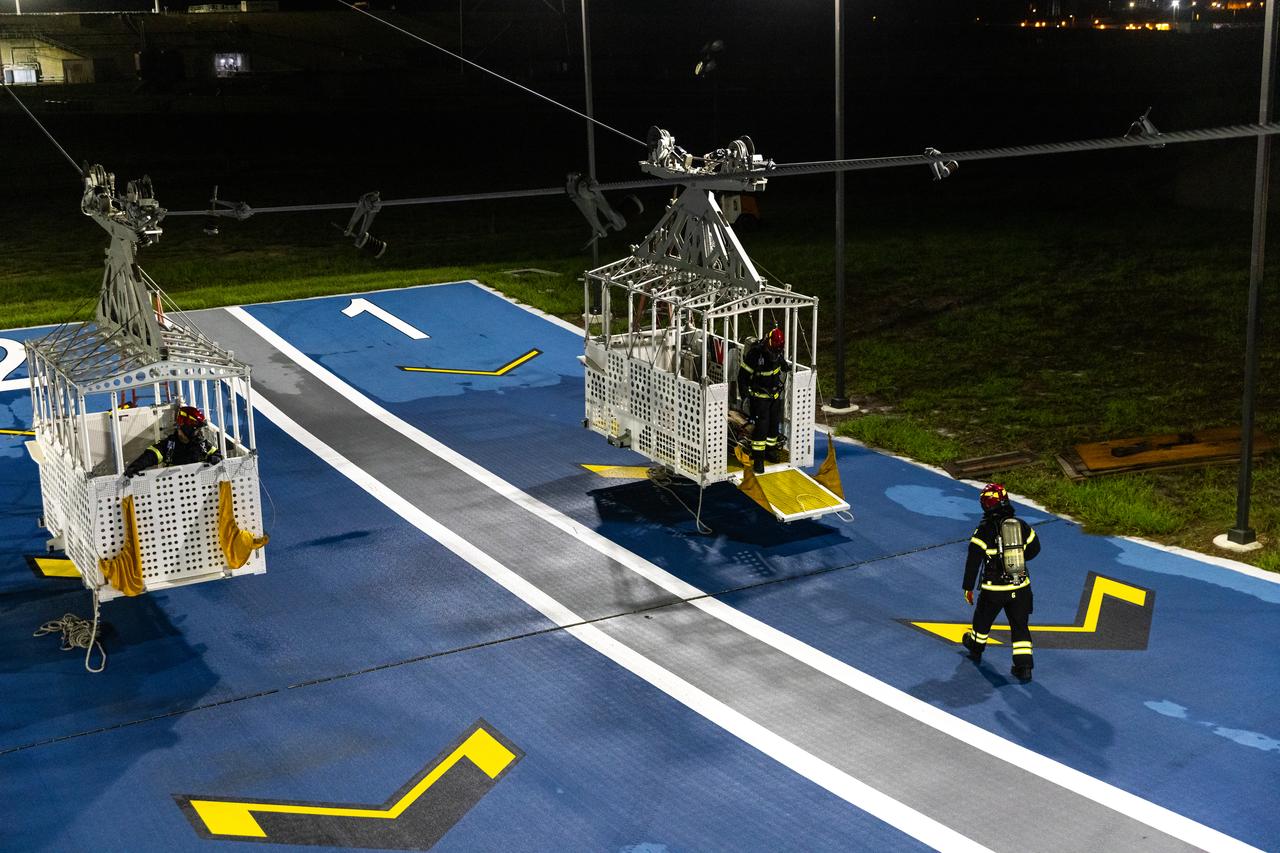 Teams at NASA’s Kennedy Space Center in Florida practice the Artemis mission emergency escape or egress procedures during a series of integrated system verification and validation tests at Launch Pad 39B on Tuesday, Aug. 13, 2024. Members of the closeout crew, pad rescue team and the Exploration Ground Systems Program practiced the process of getting inside and out of the emergency egress baskets. While the crew and other personnel will ride the emergency egress baskets to the terminus area in a real emergency, no one rode the baskets for this test. Instead, teams tested the baskets during separate occasions by using water tanks filled to different levels to replicate simulate the weight of passengers.