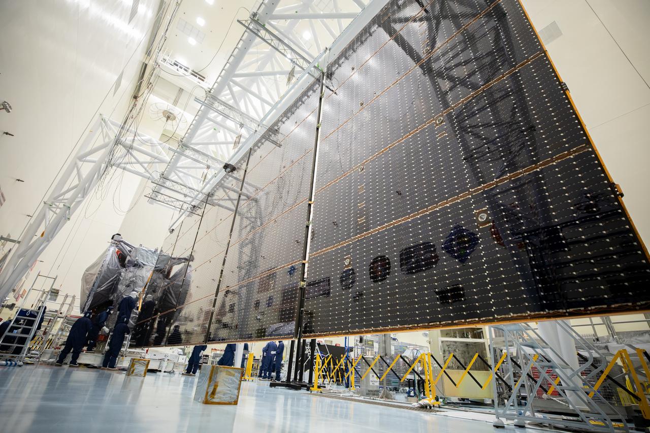 Technicians align, install, and then extend the second set of solar arrays, measuring 46.5 feet (14.2 meters) long and about 13.5 feet (4.1 meters) high, for NASA’s Europa Clipper spacecraft inside the agency’s Payload Hazardous Servicing Facility at Kennedy Space Center in Florida on Thursday, Aug. 15, 2024. The huge arrays – spanning more than 100 feet when fully deployed, or about the length of a basketball court – will collect sunlight to power the spacecraft as it flies multiple times around Jupiter’s icy moon, Europa, conducting science investigations to determine its potential to support life.