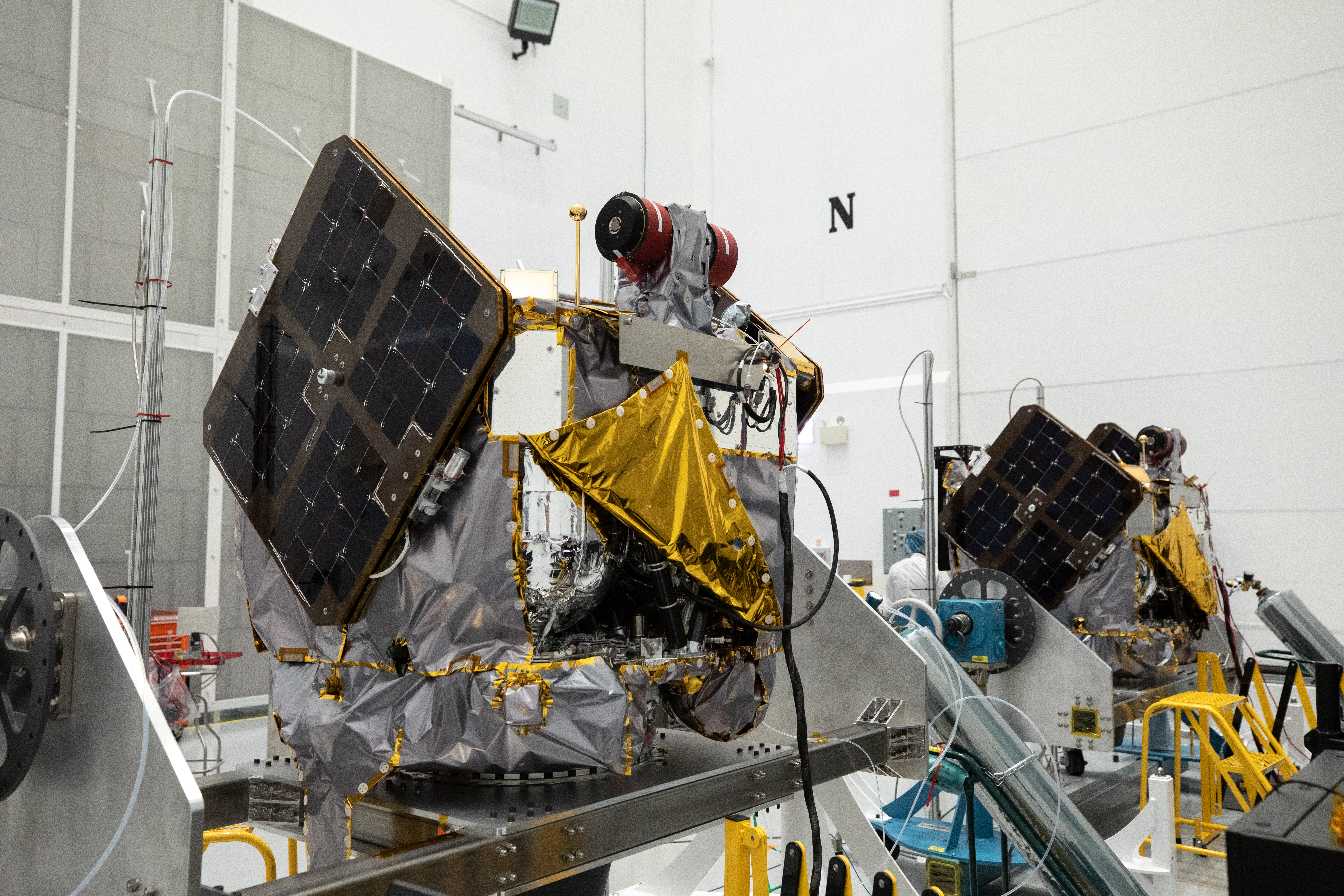 NASA’s ESCAPADE (Escape and Plasma Acceleration and Dynamics Explorers) identical dual spacecraft are inspected and processed on dollies in a high bay of the Astrotech Space Operations Facility near the agency’s Kennedy Space Center in Florida on Thursday, Aug. 22, 2024. As the first multi-spacecraft orbital science mission to Mars, ESCAPADE’s twin orbiters will take simultaneous observations from different locations around the planet and reveal the real-time response to space weather and how the Martian magnetosphere changes over time.
