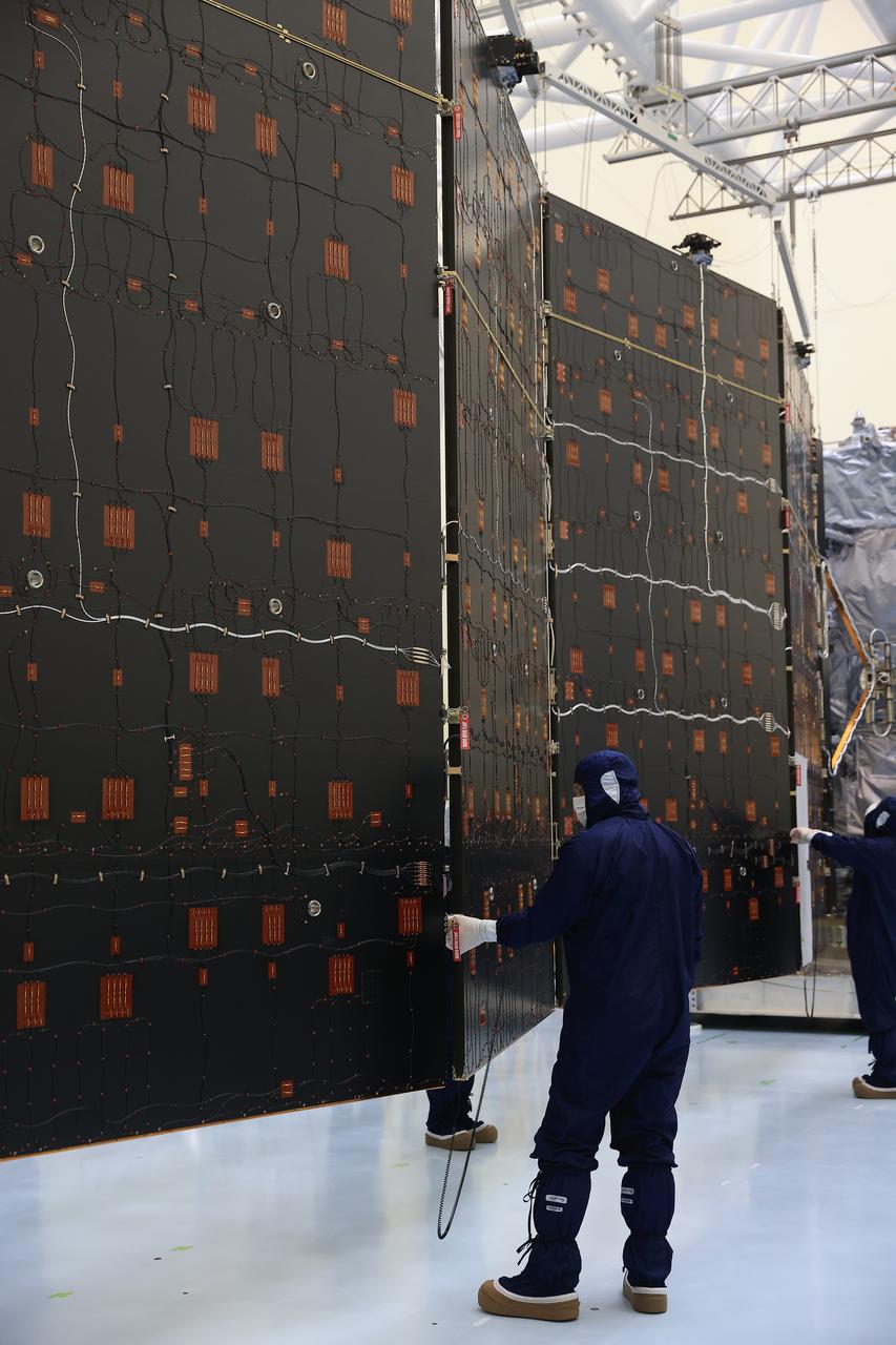 Technicians test and extend one of the two “wings” comprising the solar arrays for NASA’s Europa Clipper spacecraft on Friday, Aug. 23, 2024, at the Payload Hazardous Servicing Facility at the agency’s Kennedy Space Center in Florida. Each array measures about 46.5 feet (14.2 meters) long and about 13.5 feet (4.1 meters) high. The spacecraft needs the massive solar arrays to power to Jupiter’s icy moon Europa to help scientists better understand the astrobiological potential for habitable worlds beyond our planet.