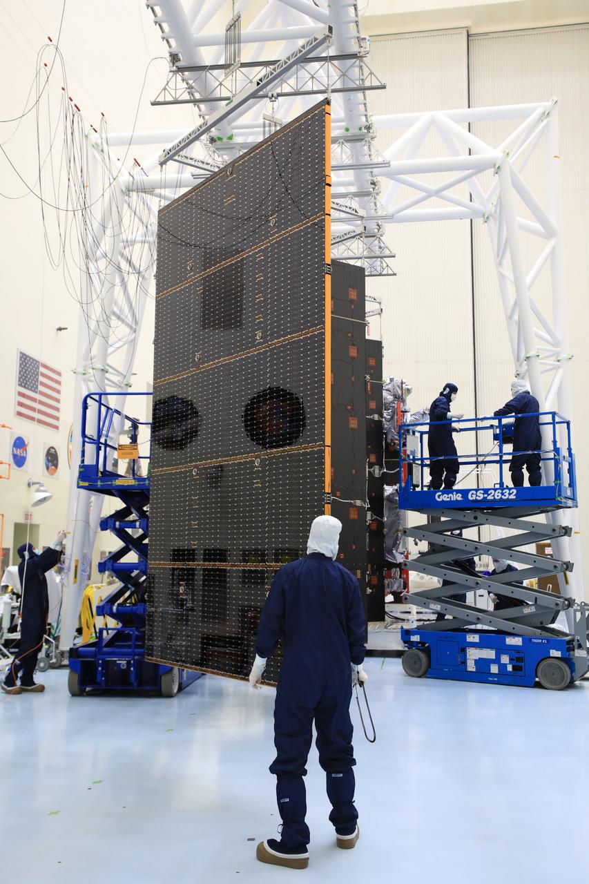 Technicians test and extend one of the two “wings” comprising the solar arrays for NASA’s Europa Clipper spacecraft on Friday, Aug. 23, 2024, at the Payload Hazardous Servicing Facility at the agency’s Kennedy Space Center in Florida. Each array measures about 46.5 feet (14.2 meters) long and about 13.5 feet (4.1 meters) high. The spacecraft needs the massive solar arrays to power to Jupiter’s icy moon Europa to help scientists better understand the astrobiological potential for habitable worlds beyond our planet.