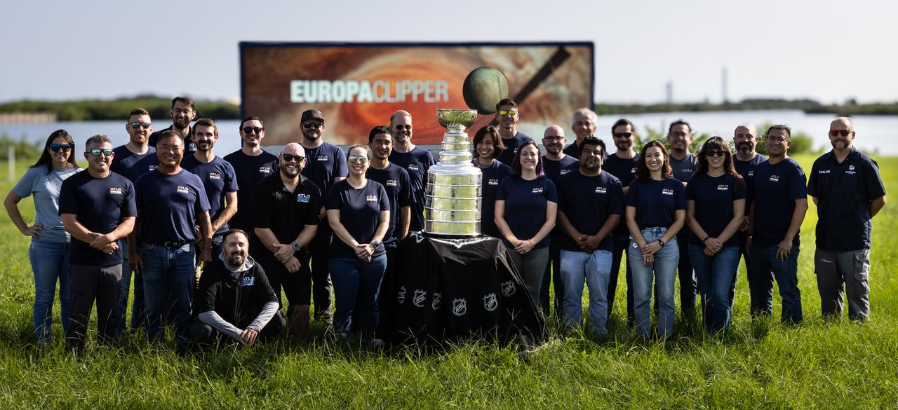 Earlier this year, the Florida Panthers won their first NHL championship and brought victory to the state of Florida. As part of its championship tour, the Stanley Cup made a visit to NASA’s Kennedy Space Center. Here, members of NASA’s Europa Clipper team pose with the National Hockey League’s Stanley Cup trophy in front of the countdown clock near the NASA News Center at Kennedy on Tuesday, Sept. 17, 2024. Europa Clipper will soon begin its Jupiter to explore if places below Europa’s surface could support life.