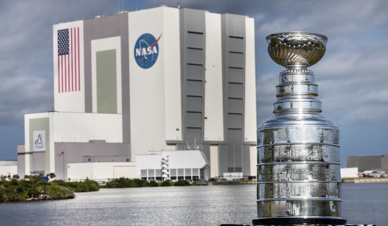 Earlier this year, the Florida Panthers won their first NHL championship and brought victory to the state of Florida. As part of its championship tour, the Stanley Cup made a visit to NASA’s Kennedy Space Center. Pictured here is the silver Stanley Cup with NASA’s iconic Vehicle Assembly Building, which currently houses components of the agency’s Artemis II mission, shown in the background at the Kennedy Space Center on Tuesday Sept. 17, 2024.