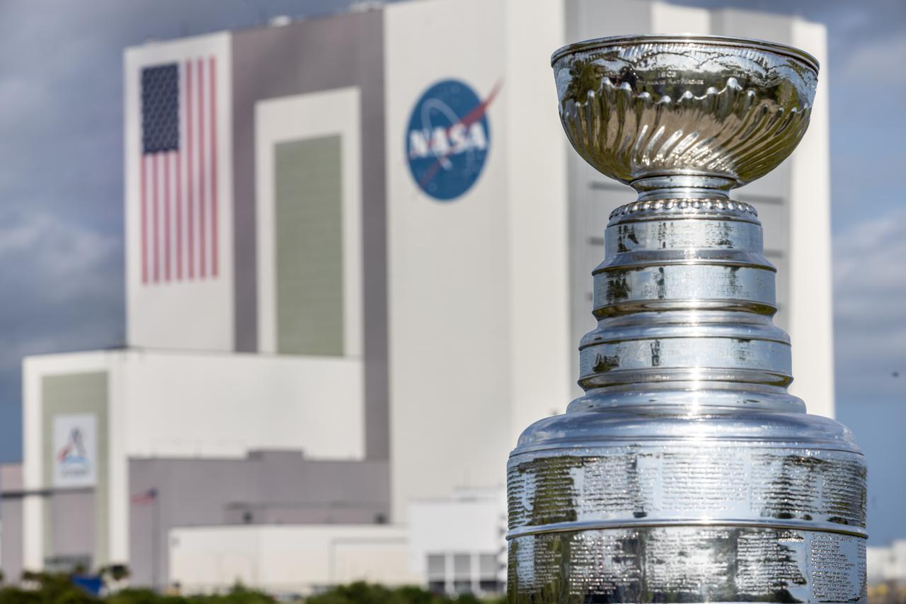 Earlier this year, the Florida Panthers won their first NHL championship and brought victory to the state of Florida. As part of its championship tour, the Stanley Cup made a visit to NASA’s Kennedy Space Center. Pictured here is the silver Stanley Cup with NASA’s iconic Vehicle Assembly Building, which currently houses components of the agency’s Artemis II mission, shown in the background at the Kennedy Space Center on Tuesday Sept. 17, 2024.