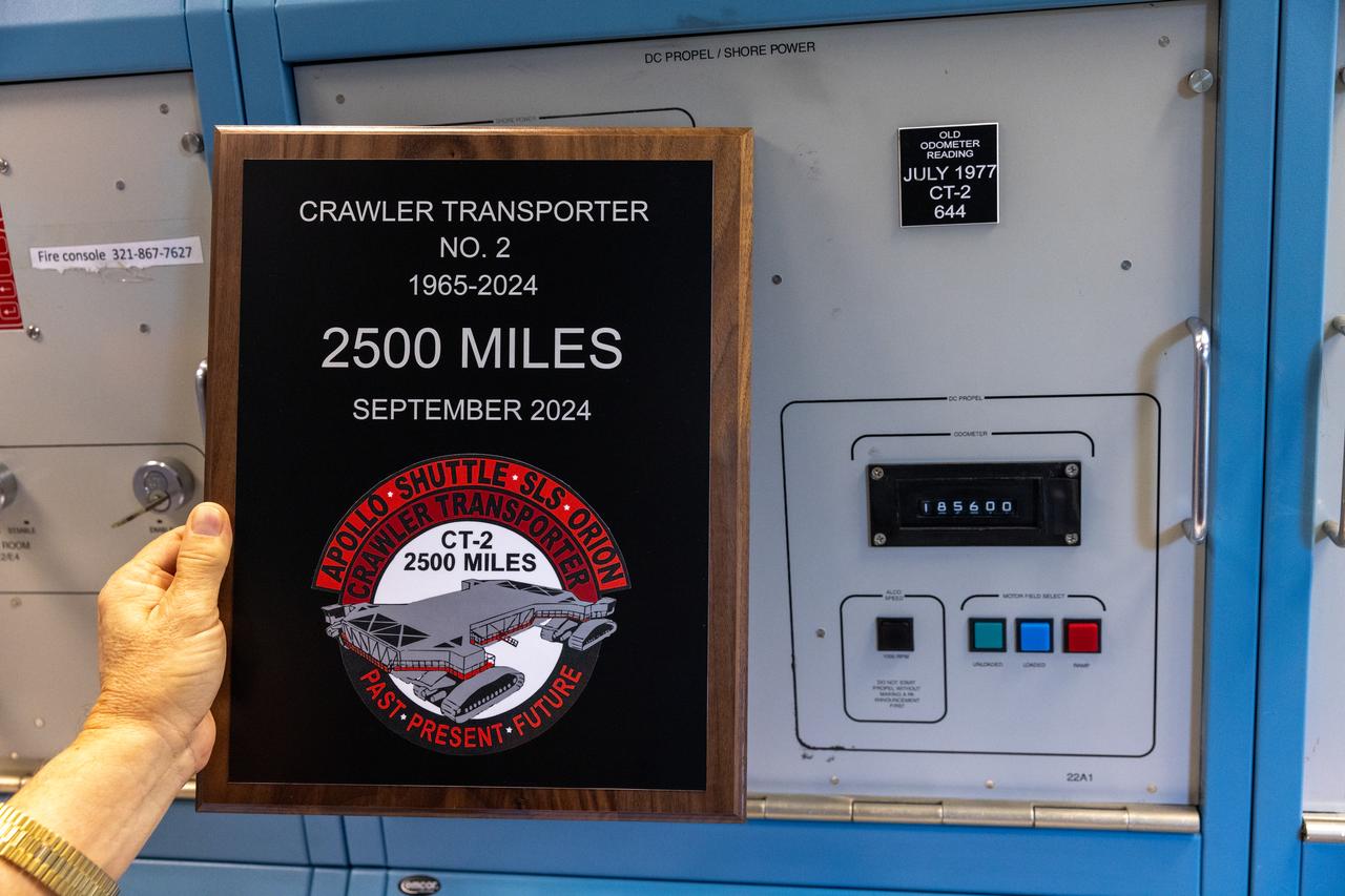 A plaque is held near the odometer of the agency’s crawler-transporter 2, on Wednesday, Sept. 25, 2024, at NASA’s Kennedy Space Center in Florida, commemorating the milestone of 2,500 miles traveled since its construction in 1965. Crawler-transporter 2 reached the milestone while teams with NASA’s Exploration Ground Systems took it on a trip in preparation for supporting the roll of the mobile launcher from Launch Pad 39B back into the spaceport’s Vehicle Assembly Building ahead of the Artemis II launch. Built originally to transport massive Saturn V rockets during the Apollo Program, crawler-transporter 2 continued its service during the Space Shuttle Program, and currently transports the massive SLS (Space Launch System) rocket and Orion spacecraft atop the mobile launcher as part of the agency’s Artemis campaign.