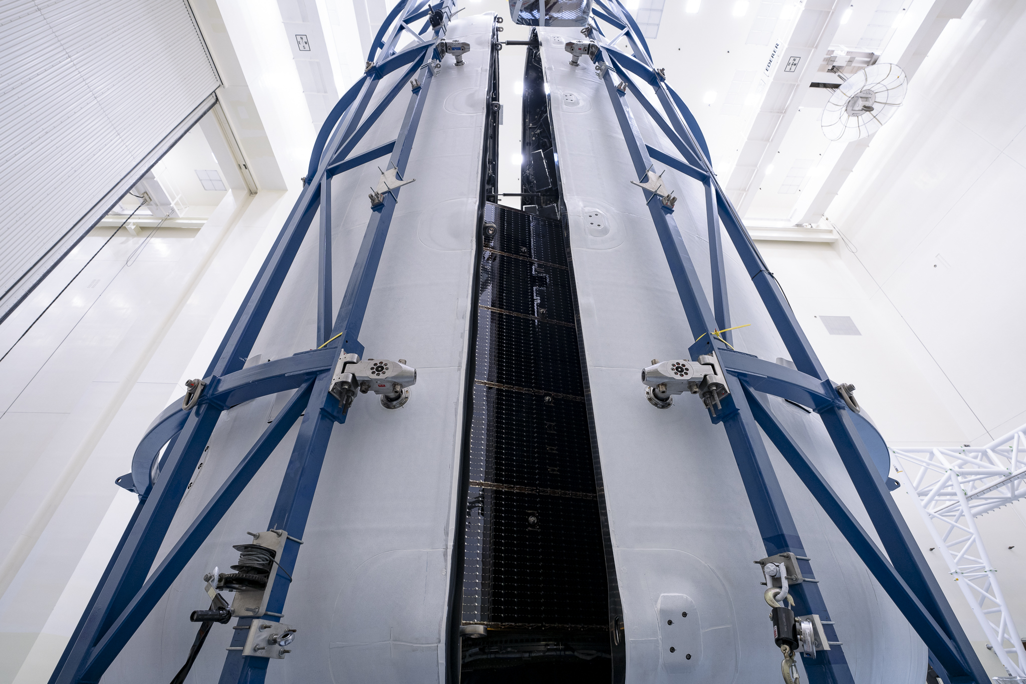 Technicians encapsulate NASA’s Europa Clipper spacecraft inside SpaceX’s Falcon Heavy payload fairing in the Payload Hazardous Servicing Facility at NASA’s Kennedy Space Center in Florida on Wednesday, Oct. 2, 2024. The payload fairing will protect the spacecraft during liftoff from Launch Complex 39A on its journey to explore Jupiter’s icy moon, Europa. The spacecraft will complete nearly 50 flybys of Jupiter’s icy moon, Europa, to determine if there are conditions suitable for life beyond Earth.