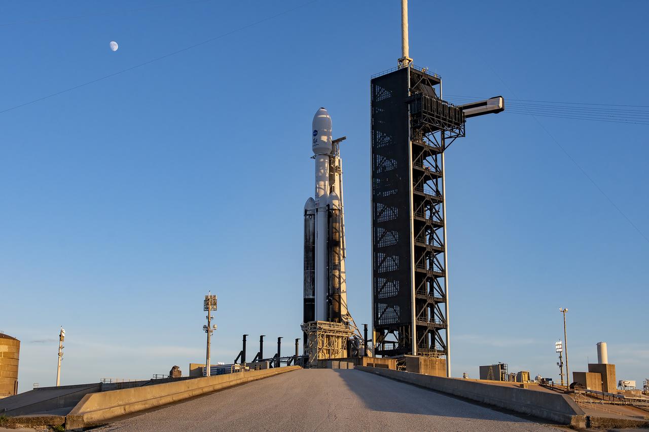 The Earth’s Moon appears with NASA’s Europa Clipper spacecraft encapsulated in a payload fairing atop SpaceX’s Heavy rocket at Launch Complex 39A on Sunday, Oct. 13, 2024, at the agency’s Kennedy Space Center in Florida. The Europa Clipper spacecraft will travel to Jupiter’s icy moon Europa to determine if there are conditions suitable for life beyond Earth.