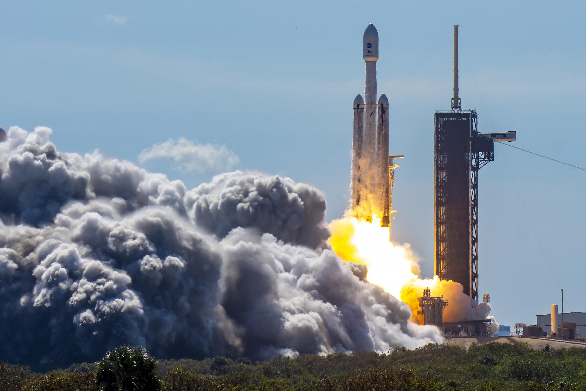 Image shows a plume of water vapor and a white and black SpaceX Falcon Heavy rocket lifting of on Monday, Oct. 14, 2024, from Launch Complex 39A at NASA's Kennedy Space Center. The Falcon Heavy carrying NASA's Europa Clipper set to investigate Jupiter's icy moon Europa for the ingredients that can support life. Photo credit: SpaceX