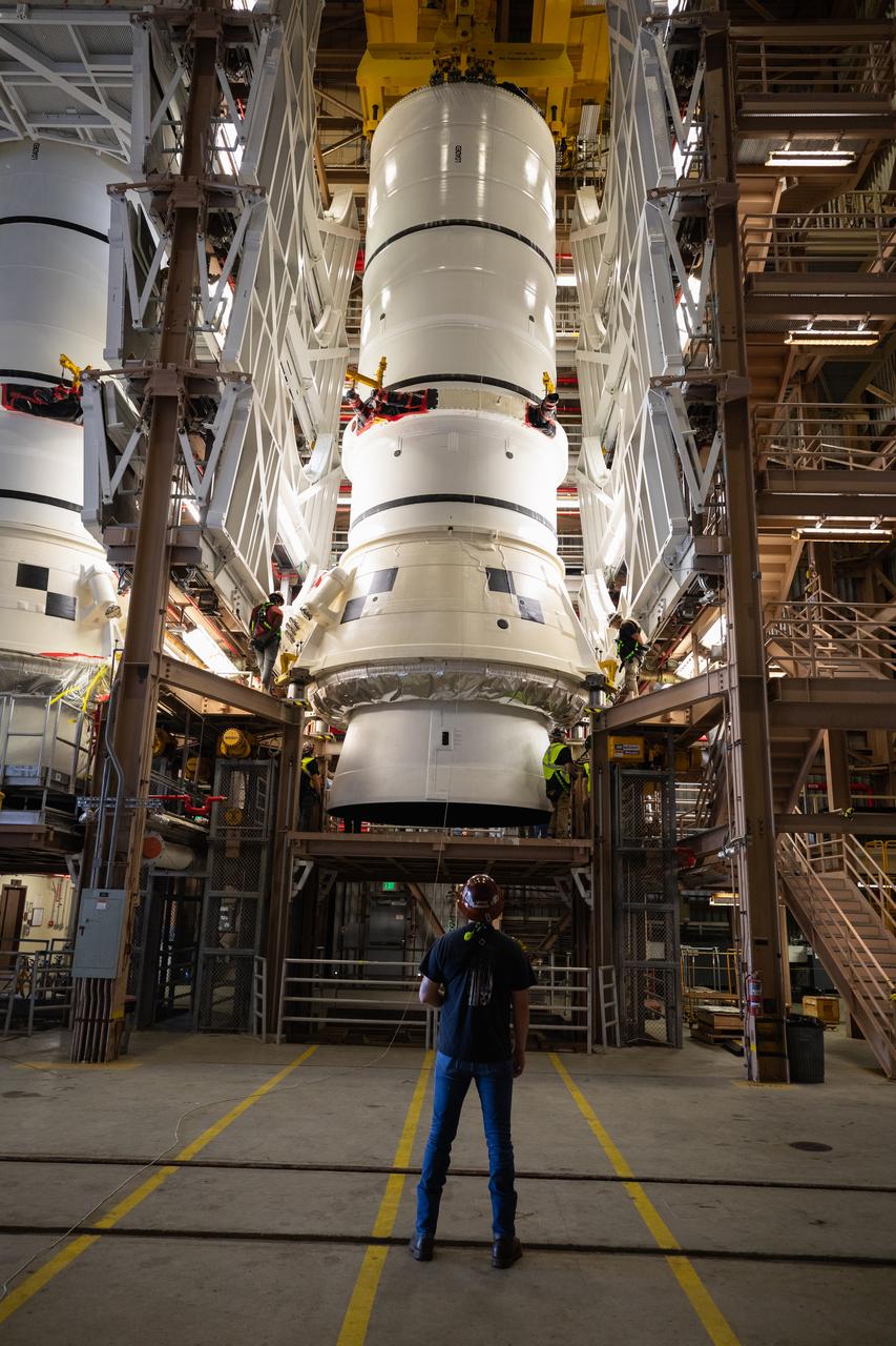 Engineers and technicians with the Exploration Ground Systems Program prepare to transfer one of the aft assemblies of the SLS (Space Launch System) solid rocket boosters for the Artemis II mission with an overhead crane inside the Rotation, Processing and Surge Facility at NASA’s Kennedy Space Center in Florida on Wednesday, Nov. 13, 2024. The booster segments are being transferred to the NASA Kennedy’s Vehicle Assembly Building via a transporter for stacking operations in preparation for launch of the Artemis II mission.