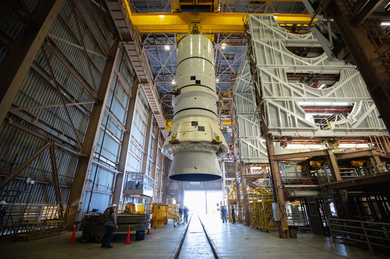 Engineers and technicians with the Exploration Ground Systems Program prepare to transfer one of the aft assemblies of the SLS (Space Launch System) solid rocket boosters for the Artemis II mission with an overhead crane inside the Rotation, Processing and Surge Facility at NASA’s Kennedy Space Center in Florida on Wednesday, Nov. 13, 2024. The booster segments are being transferred to the NASA Kennedy’s Vehicle Assembly Building via a transporter for stacking operations in preparation for launch of the Artemis II mission.