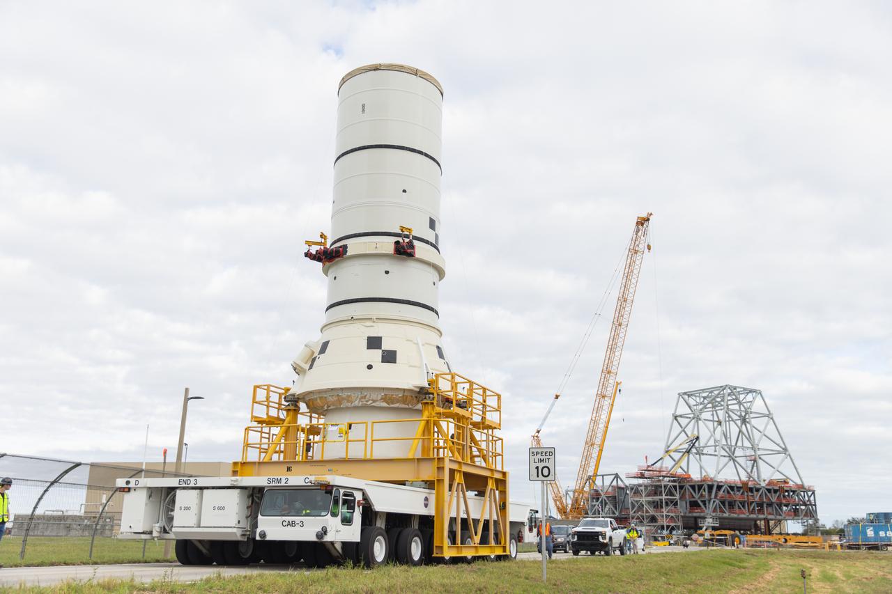 The left aft assembly of the SLS (Space Launch System) solid rocket boosters for the Artemis II mission is moved from the Rotation, Processing and Surge Facility to the Vehicle Assembly Building at NASA’s Kennedy Space Center in Florida on Monday, Nov. 18, 2024. The aft assembly will be lifted atop the mobile launcher, followed by the right aft assembly and remaining booster segments. 