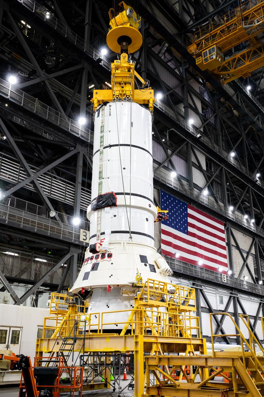 Engineers and technicians with the Exploration Ground Systems Program attach an overhead crane to the left aft assembly, or bottom portion of the solid rocket boosters for the SLS (Space Launch System) rocket, inside the Vehicle Assembly Building at NASA’s Kennedy Space Center on Tuesday, Nov. 19, 2024. The crane will lift the aft assembly on top of mobile launcher 1 followed by the right aft assembly and stack the remaining booster segments for the Artemis II mission.  