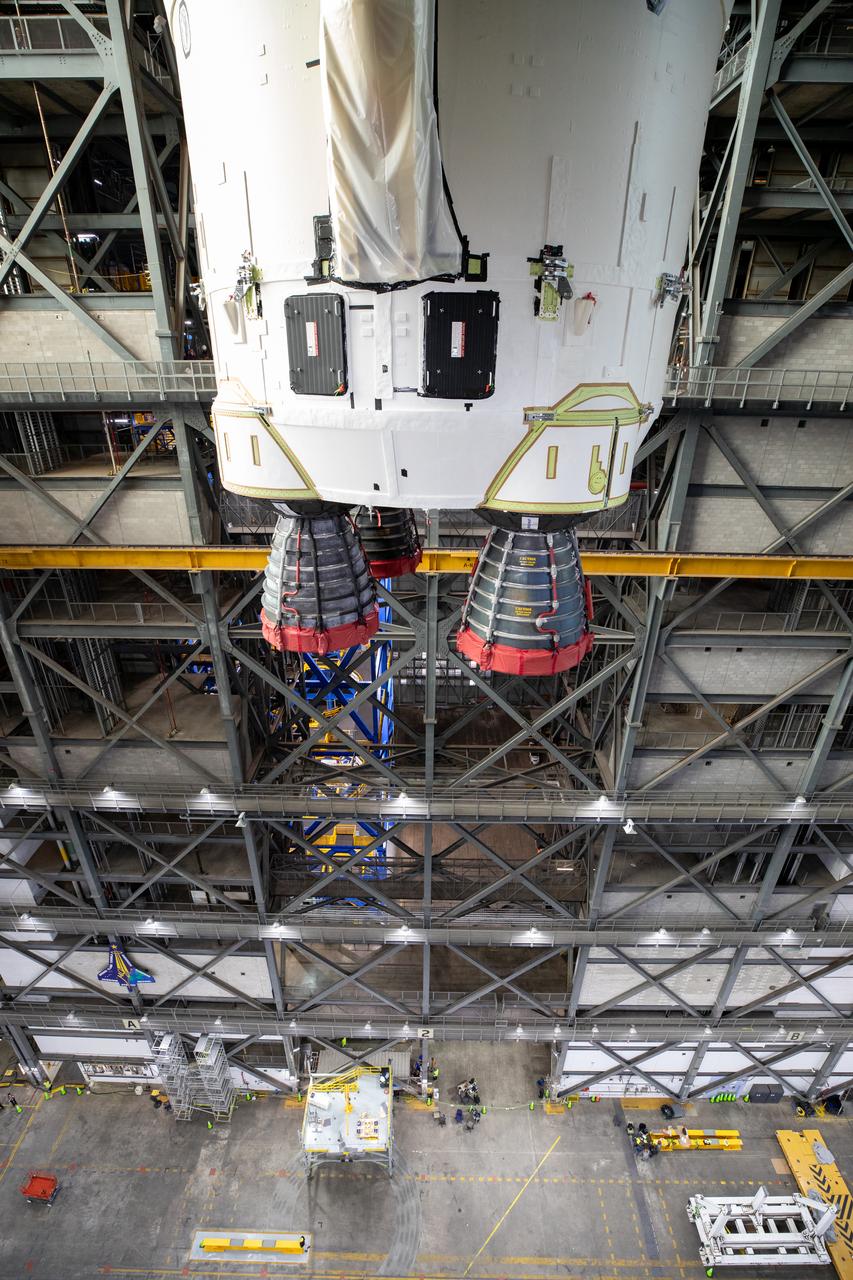 Teams with NASA’s Exploration Ground Systems transport the agency’s 212-foot-tall SLS (Space Launch System) core stage into High Bay 2 at the Vehicle Assembly Building at NASA’s Kennedy Space Center in Florida on Wednesday, Dec. 11, 2024. The one-of-a kind lifting beam is designed to lift the core stage from the transfer aisle to High Bay 2 where it will remain while teams stack the two solid rocket boosters on top of mobile launcher 1 for the SLS core stage.