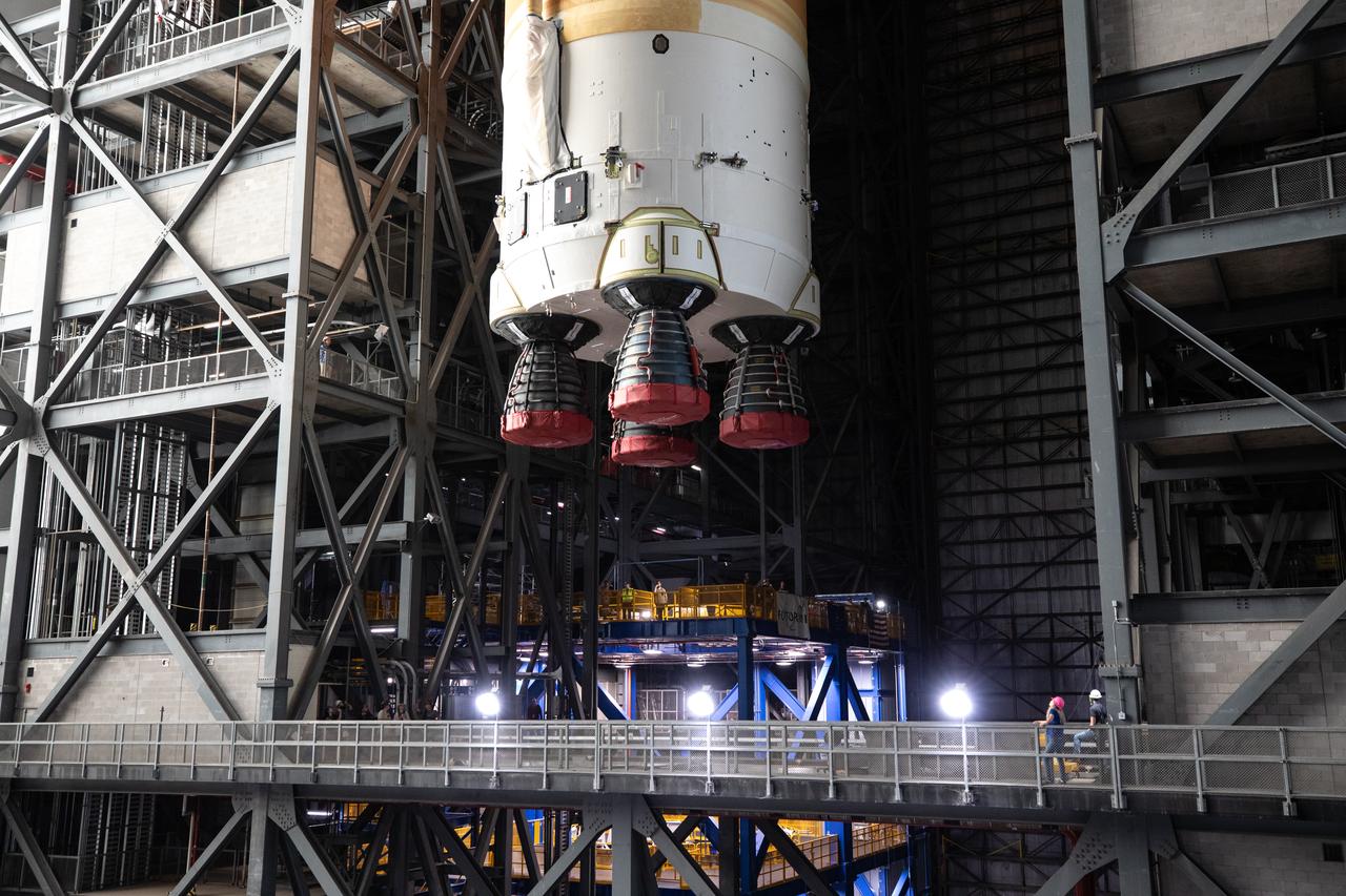 Teams with NASA’s Exploration Ground Systems transport the agency’s 212-foot-tall SLS (Space Launch System) core stage into High Bay 2 at the Vehicle Assembly Building at NASA’s Kennedy Space Center in Florida on Wednesday, Dec. 11, 2024. The one-of-a kind lifting beam is designed to lift the core stage from the transfer aisle to High Bay 2 where it will remain while teams stack the two solid rocket boosters on top of mobile launcher 1 for the SLS core stage.