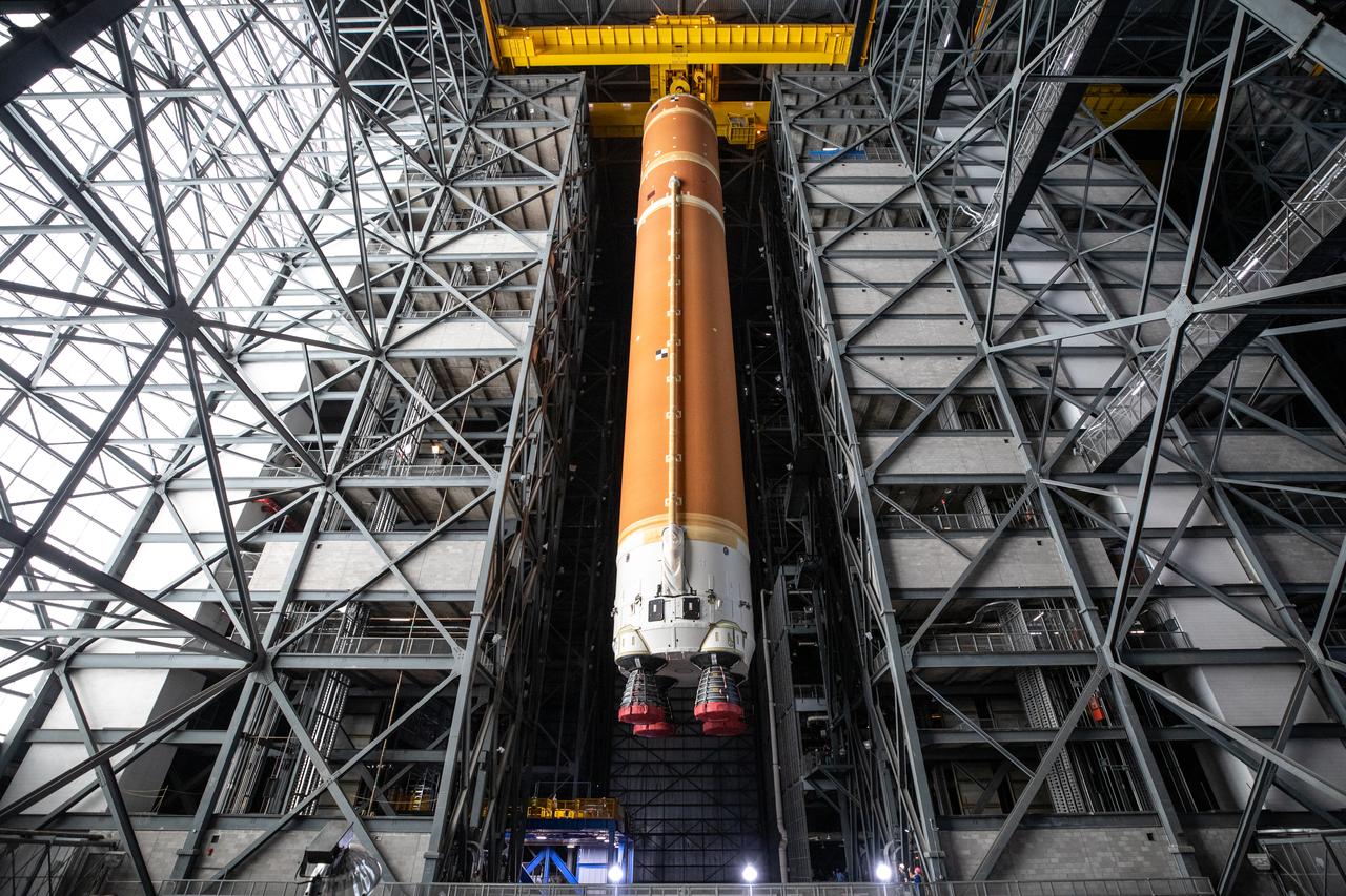 Teams with NASA’s Exploration Ground Systems transport the agency’s 212-foot-tall SLS (Space Launch System) core stage into High Bay 2 at the Vehicle Assembly Building at NASA’s Kennedy Space Center in Florida on Wednesday, Dec. 11, 2024. The one-of-a kind lifting beam is designed to lift the core stage from the transfer aisle to High Bay 2 where it will remain while teams stack the two solid rocket boosters on top of mobile launcher 1 for the SLS core stage.