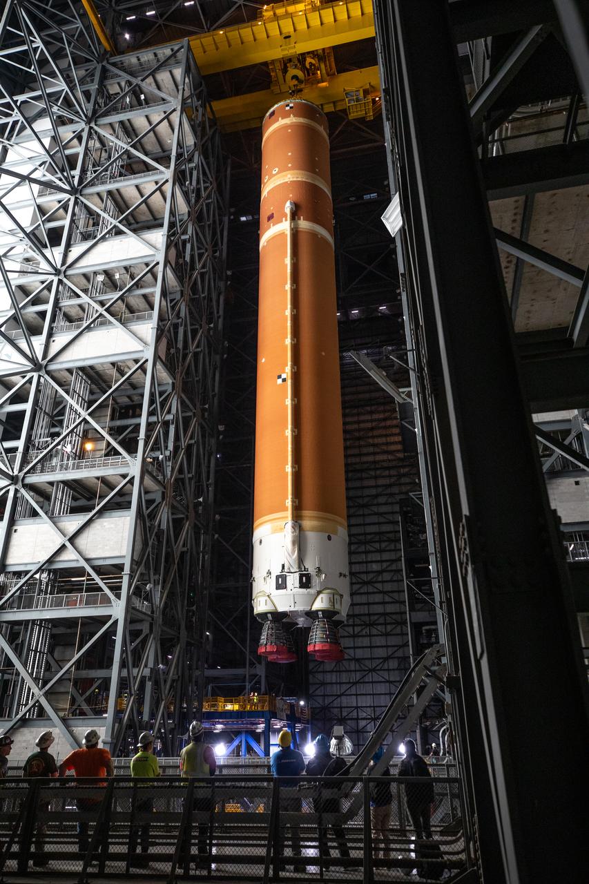 Teams with NASA’s Exploration Ground Systems transport the agency’s 212-foot-tall SLS (Space Launch System) core stage into High Bay 2 at the Vehicle Assembly Building at NASA’s Kennedy Space Center in Florida on Wednesday, Dec. 11, 2024. The one-of-a kind lifting beam is designed to lift the core stage from the transfer aisle to High Bay 2 where it will remain while teams stack the two solid rocket boosters on top of mobile launcher 1 for the SLS core stage.