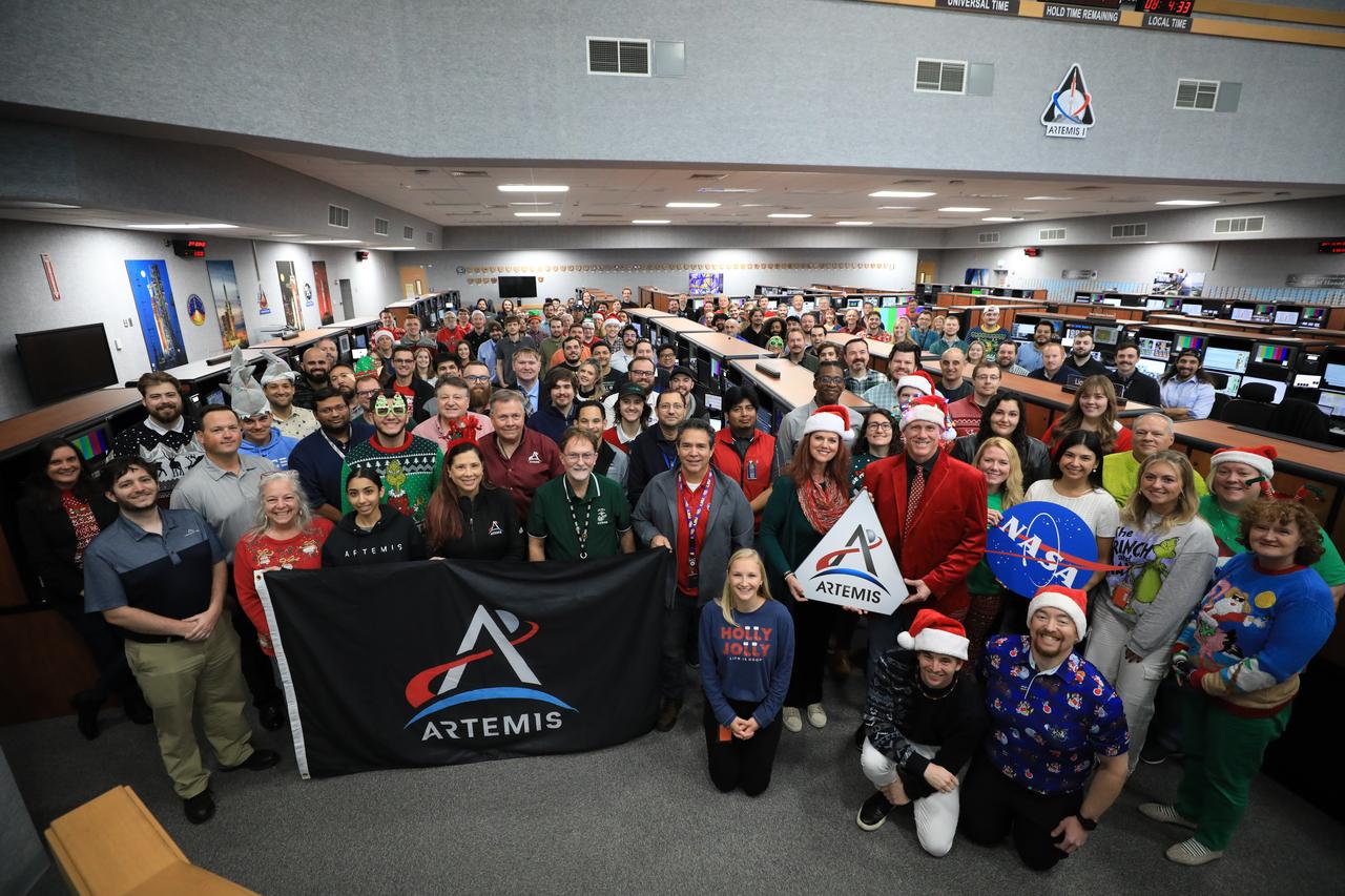 Members of the Artemis launch team pose for a holiday group photo in Firing Room 1 inside the Launch Control Center at NASA’s Kennedy Space Center in Florida on Thursday, Dec. 12, 2024. Teams participated in a cryogenic and terminal count simulation for Artemis II. The simulations go through launch day scenarios to help launch team members test software and make any necessary adjustments during countdown operations. Four astronauts will venture around the Moon on Artemis II, the first crewed mission on NASA’s path to establishing a long-term presence for science and exploration through Artemis.