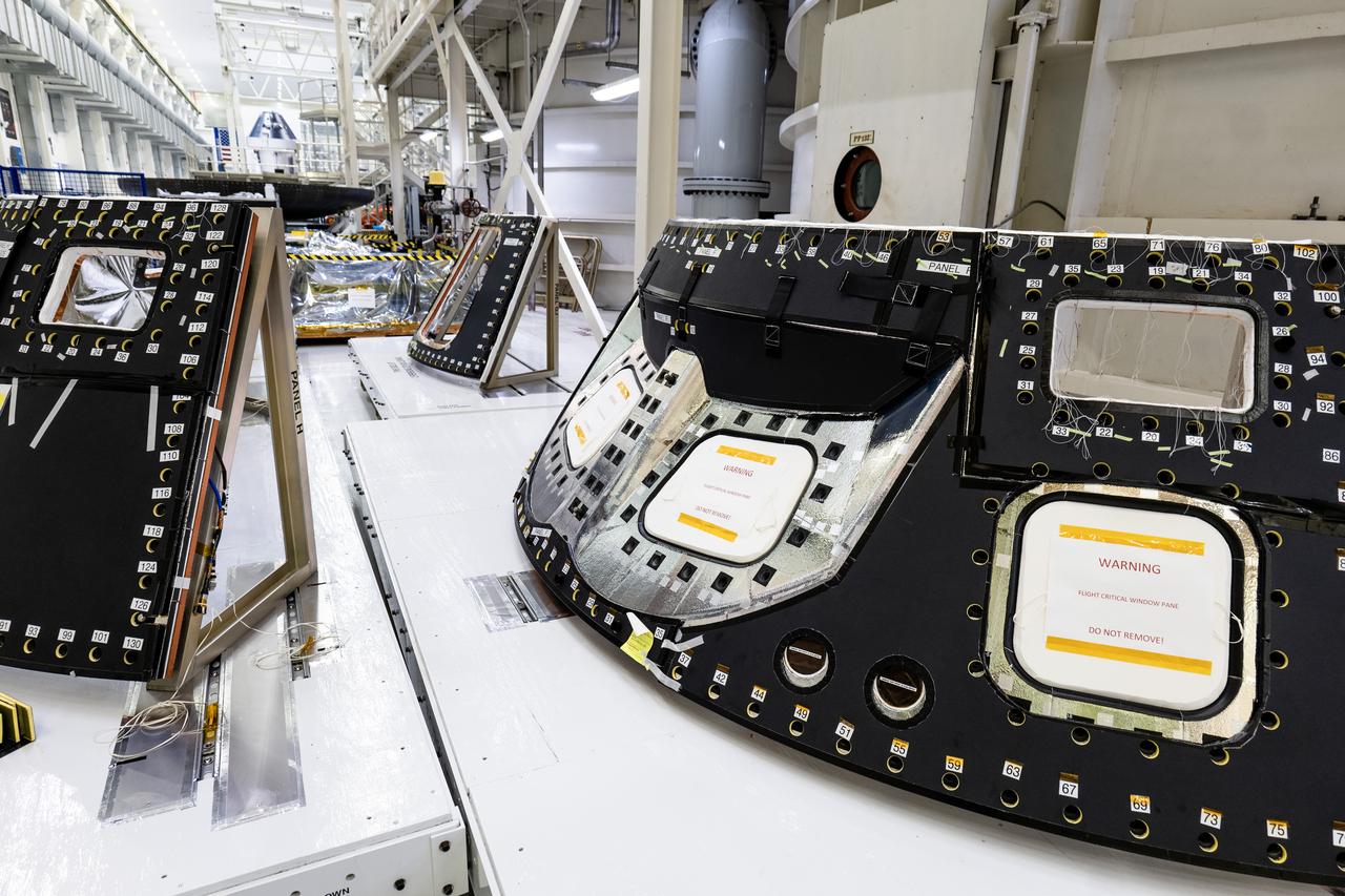 Visible in the foreground are back shell panels on the Orion spacecraft for the Artemis II mission inside the Neil A. Armstrong Operations and Checkout Building high bay at NASA's Kennedy Space Center in Florida on Monday, Dec. 15, 2024. The back shell panels serve as the outer layer of the spacecraft and will protect it against the extreme temperatures of re-entry from deep space. In the background are the heat shield for Orion’s Artemis IV mission secured on a work stand, as well as the Orion spacecraft for NASA’s Artemis II mission.