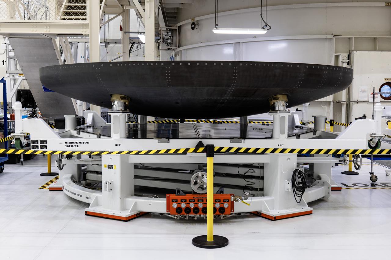 The heat shield carrier for Orion’s Artemis IV mission is in view secured on a work stand in the Neil A. Armstrong Operations and Checkout Building high bay at NASA’s Kennedy Space Center in Florida on Monday, Dec. 15, 2024. The carrier structure holds the thermal protection system heat shield securely to the Orion crew module while facing launch, reentry, and splashdown impact loads. 
