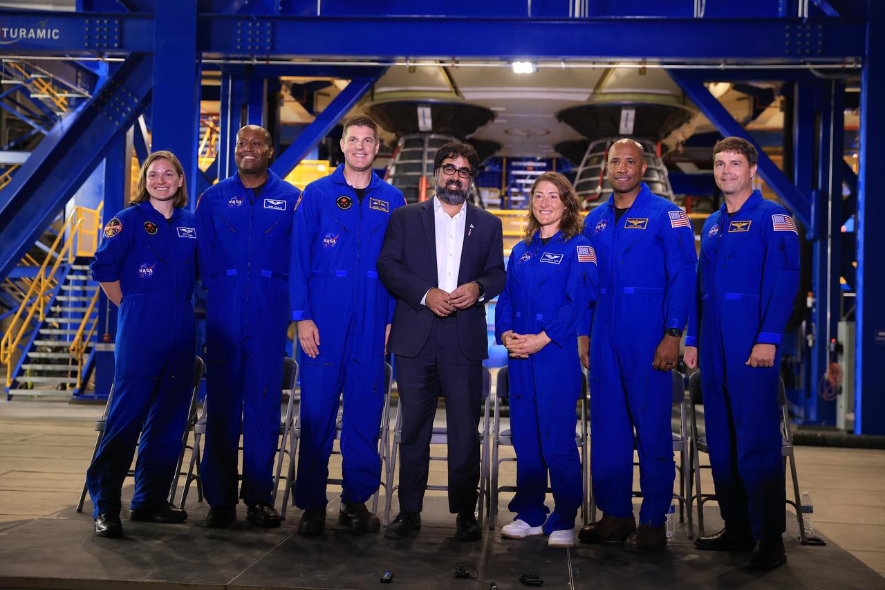 From left, CSA (Canadian Space Agency) astronaut Jenni Gibbons, NASA astronaut Andre Douglas, CSA astronaut Jeremy Hansen, NASA Moon to Mars Program Deputy Associate Administrator Amit Kshatriya, and NASA astronauts Christina Koch, Victor Glover, and Reid Wiseman participate in a media day event on Monday, Dec. 16, 2024, inside the Vehicle Assembly Building at the agency’s Kennedy Space Center in Florida. The Artemis II crew and backup crew participated in the event days after teams with NASA’s Exploration Ground Systems transport lifted the agency’s 212-foot-tall SLS (Space Launch System) core stage from the facility’s transfer aisle into High Bay 2 where it will remain while teams stack the two solid rocket boosters on top of mobile launcher 1.