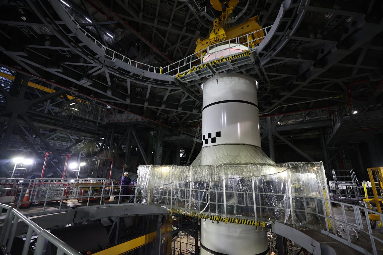 Engineers and technicians with the Exploration Ground Systems Program stack the next solid rocket booster segment, the left aft center, on the for the Artemis II SLS (Space Launch System) Moon rocket onto mobile launcher 1 inside the Vehicle Assembly Building’s High Bay 3 at NASA’s Kennedy Space Center on Thursday, Dec. 19, 2024. Once assembled, the boosters will help support the remaining rocket components and the Orion spacecraft during final assembly of the Artemis II Moon rocket and provide more than 75 percent of the total SLS thrust during liftoff from NASA Kennedy’s Launch Pad 39B.