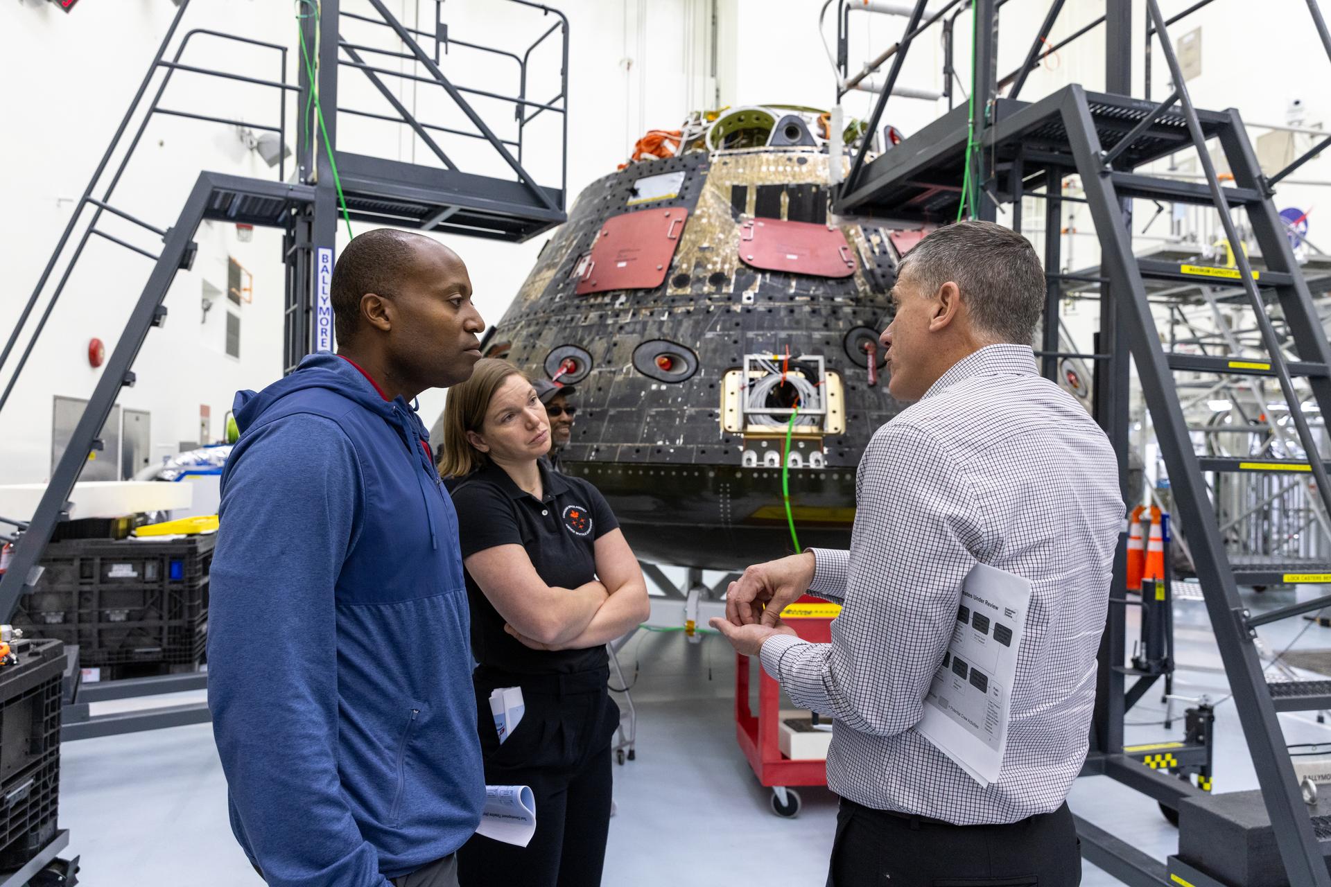 NASA astronaut Andre Douglas (left) and Canadian Space Agency astronaut Jenni Gibbons seen during a visit at NASA’s Kennedy Space Center on Thursday, Jan. 16, 2025. In the background is the Orion Environmental Test Article spacecraft which was flown around the Moon and back during Artemis I on Nov. 16, 2022. Douglas and Gibbons were backup crew members for Artemis II.