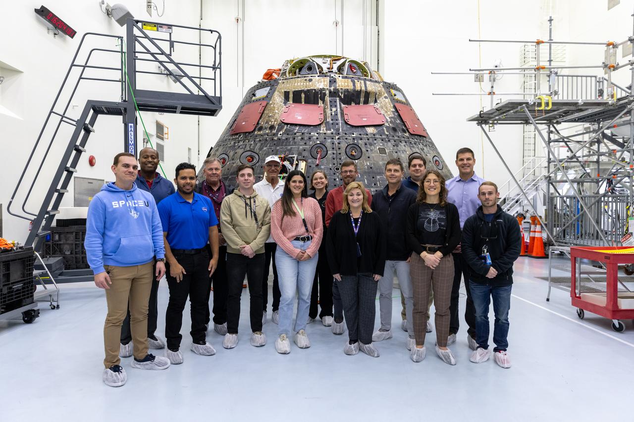 Crew members and backup crew members of the Artemis II team pose for a photo with NASA’s Exploration Ground Systems and Lockheed Martin teams during a visit to Kennedy Space Center in Florida on Thursday, Jan. 16, 2025. In the background is the Orion Environmental Test Article spacecraft which was flown around the Moon and back during Artemis I on Nov. 16, 2022. Orion will carry four astronauts around the Moon and back during the Artemis II mission.